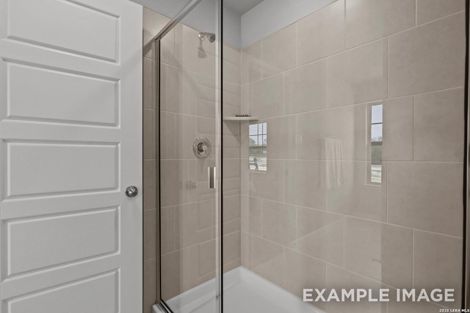 Walk-in shower with tiled walls and glass door in The Gillian A floor plan home by Davidson Homes in San Antonio, TX.