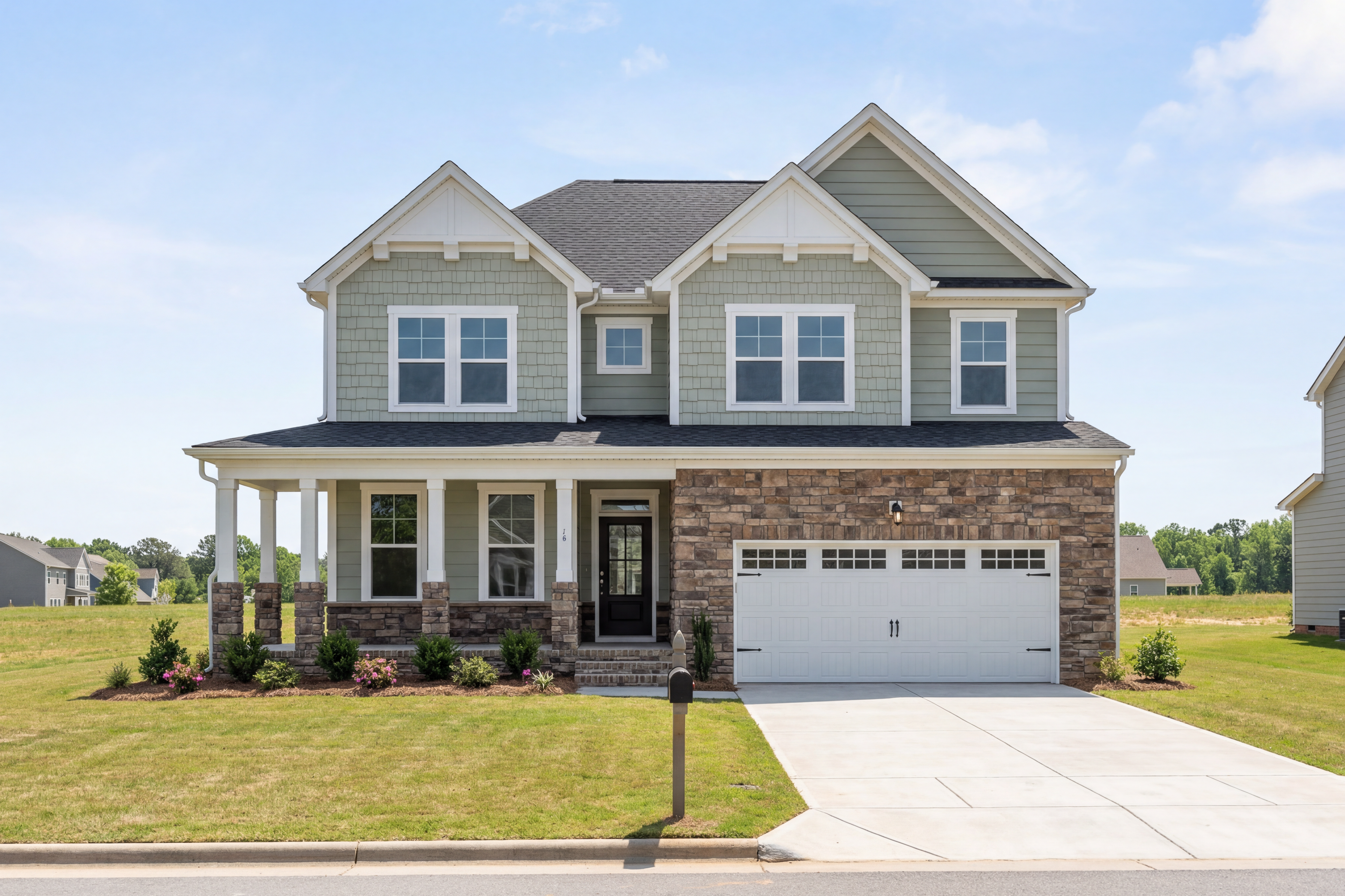 Two-story The Willow G home elevation in gray siding, brick accents, covered porch, and 2-car garage by Davidson Homes in Wake Forest NC