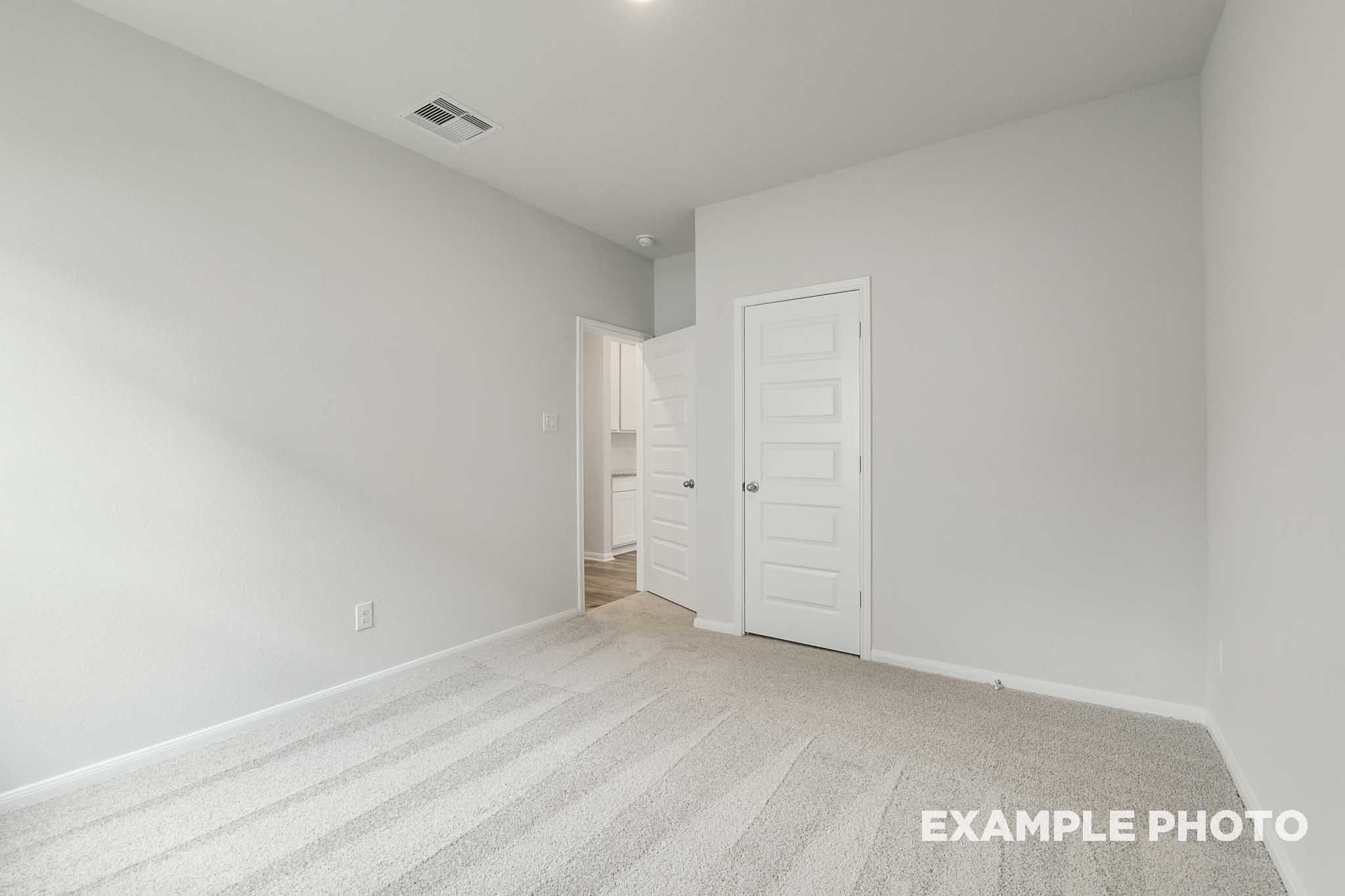 Bright, carpeted bedroom in The Frio floor plan by Davidson Homes featuring neutral walls and interior door access.