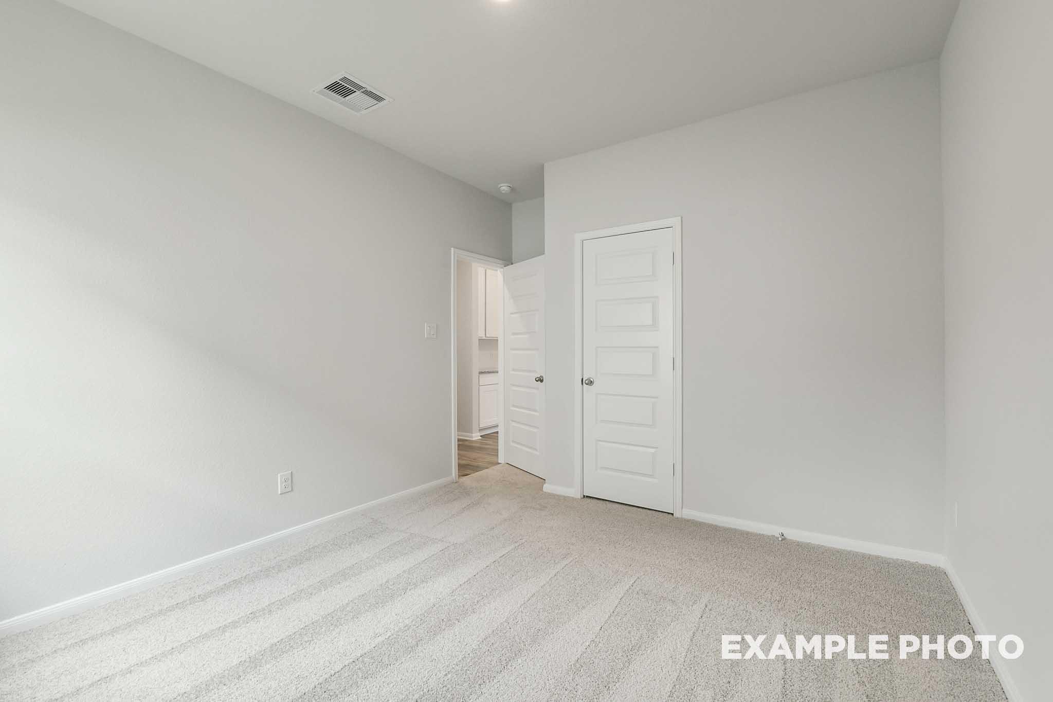 Bright, carpeted bedroom in The Frio floor plan by Davidson Homes featuring neutral walls and interior door access.