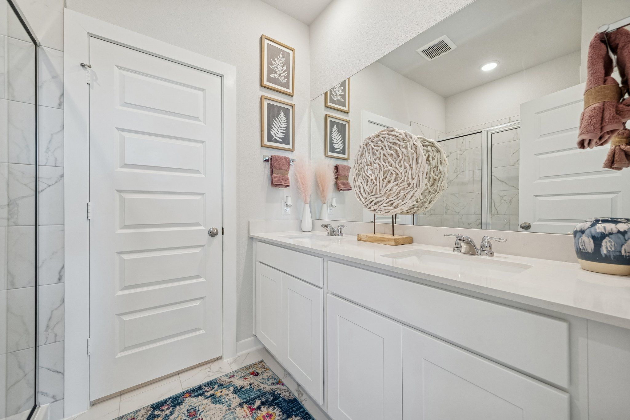 Spacious modern bathroom at Spring Branch Crossing in Conroe Texas with white shaker cabinets, quartz vanity, subway tile shower