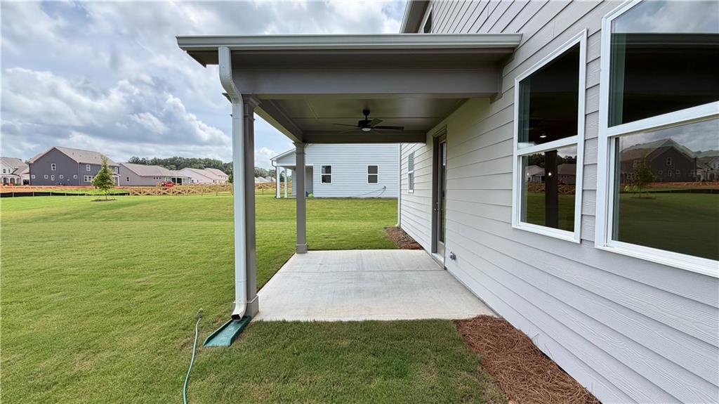 Covered back patio with ceiling fan at The Hickory C floor plan in Wehunt Meadows, Hoschton, Georgia.