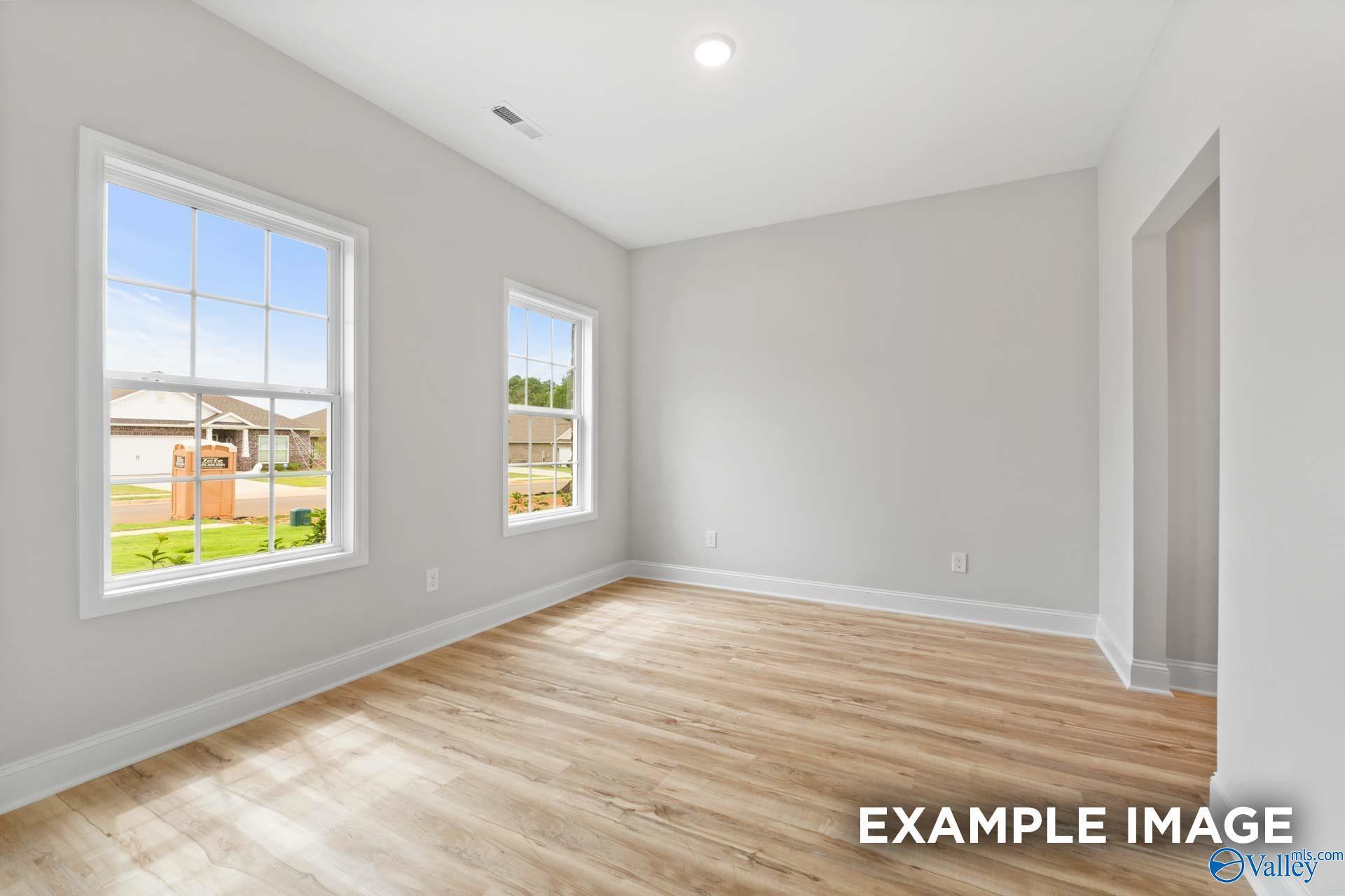Bright, neutral bedroom with light wood flooring in The Shelby B floor plan by Davidson Homes, Jaguar Hills, Huntsville.