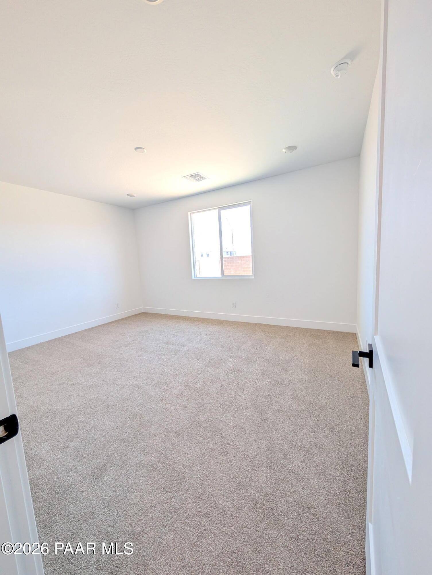 Bright, carpeted bedroom in The Frontier II F floor plan at South Ranch Western Collection in Prescott, Arizona.