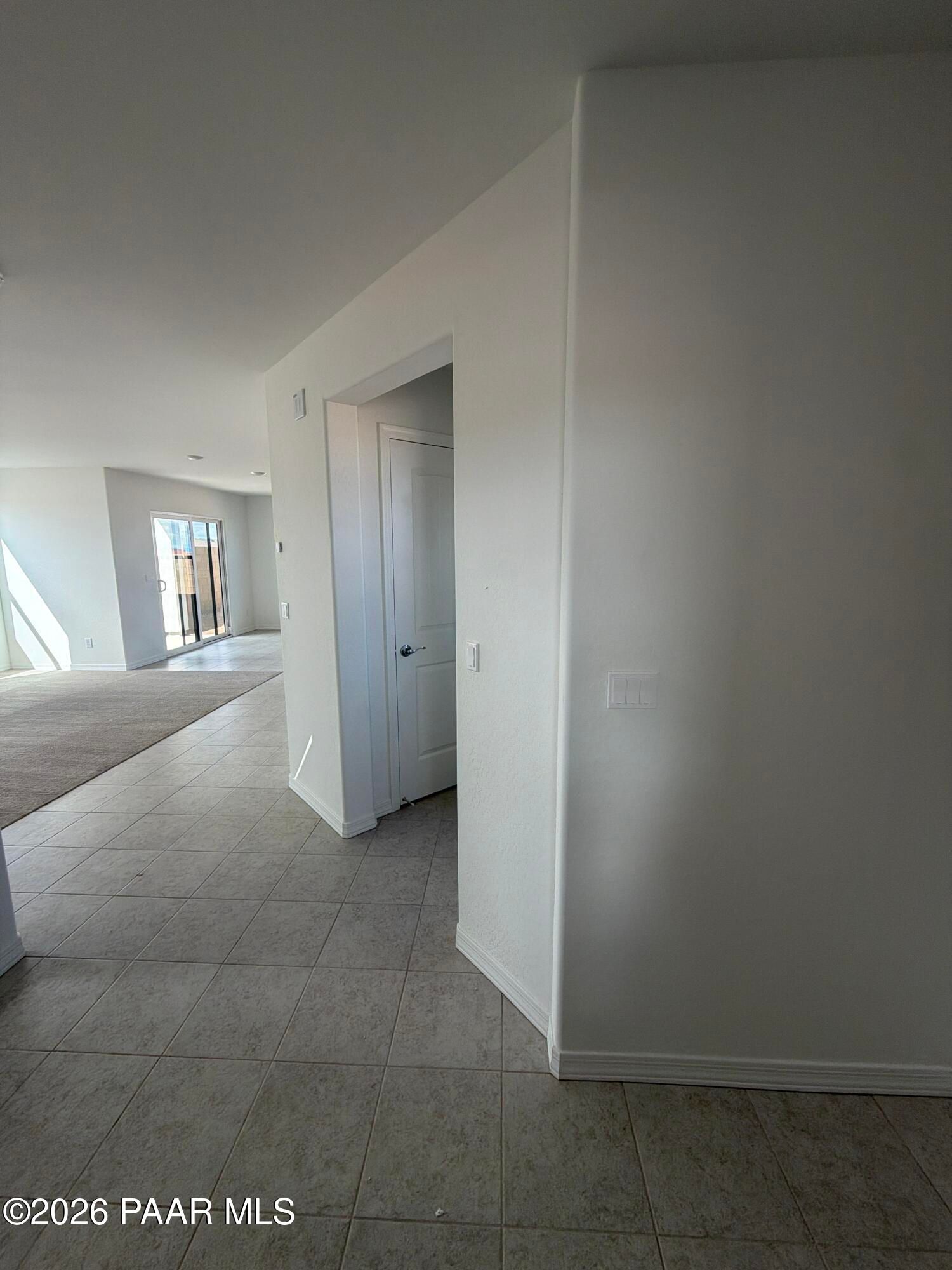 Bright tile entryway opening to carpeted living area with sliding glass door in Davidson Homes Wilmington B, Prescott AZ