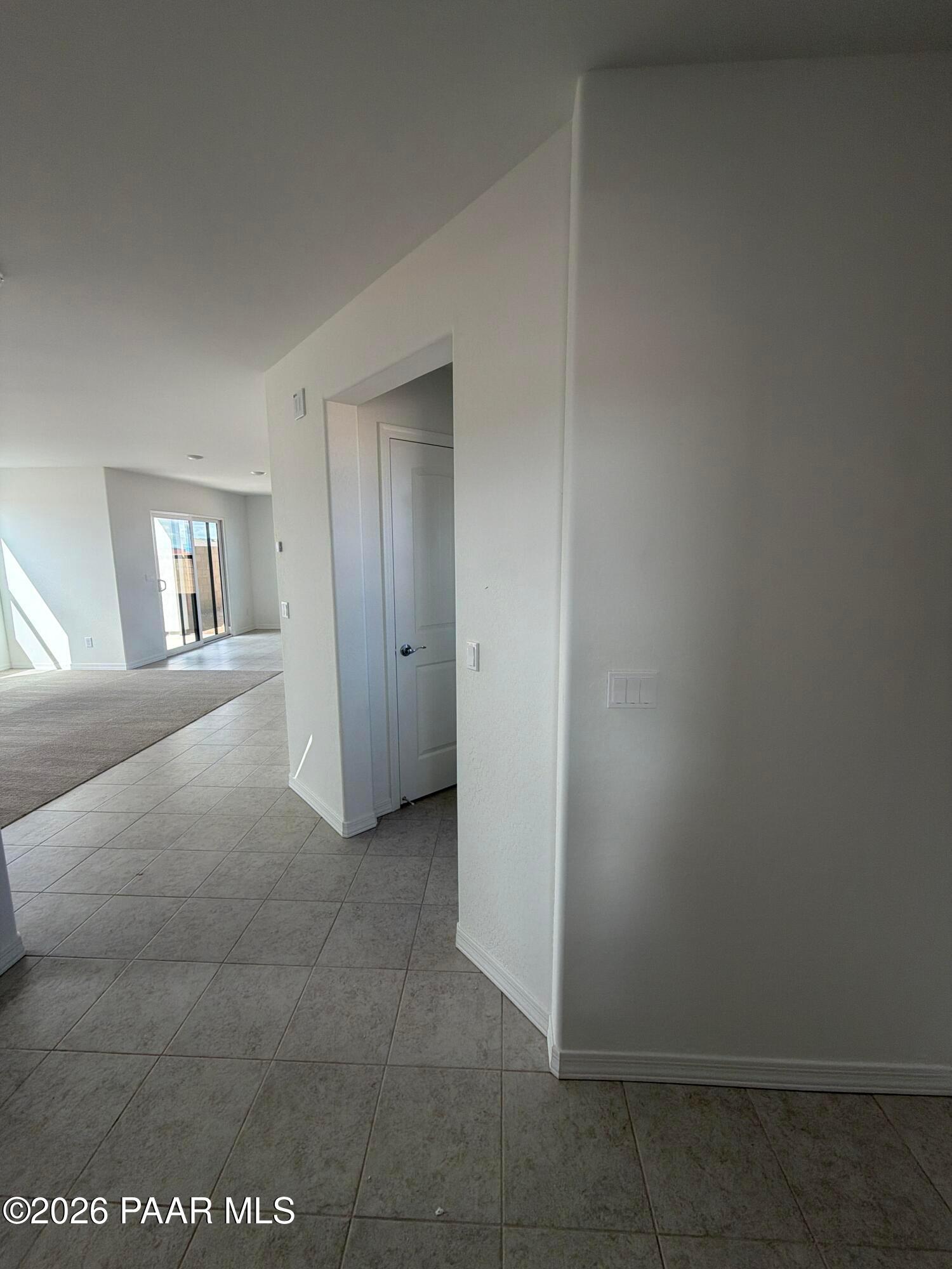 Bright tile entryway opening to carpeted living area with sliding glass door in Davidson Homes Wilmington B, Prescott AZ