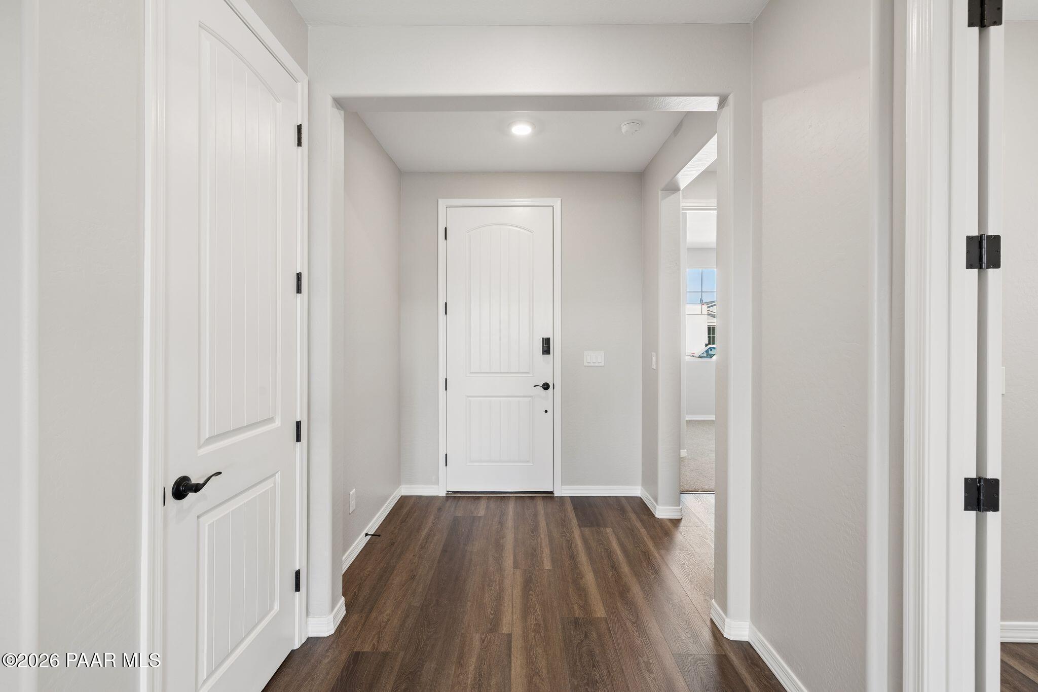 Bright entry hallway with white paneled doors, light gray walls, and wood-look flooring in Davidson Homes The Durango II B, Prescott, AZ