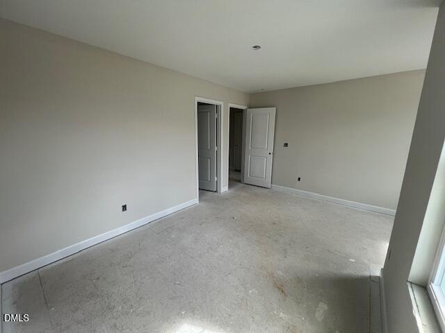 Empty secondary bedroom featuring beige walls, double doors, carpet flooring, and window in 4-bed Davidson Homes Preston A, Lillington NC