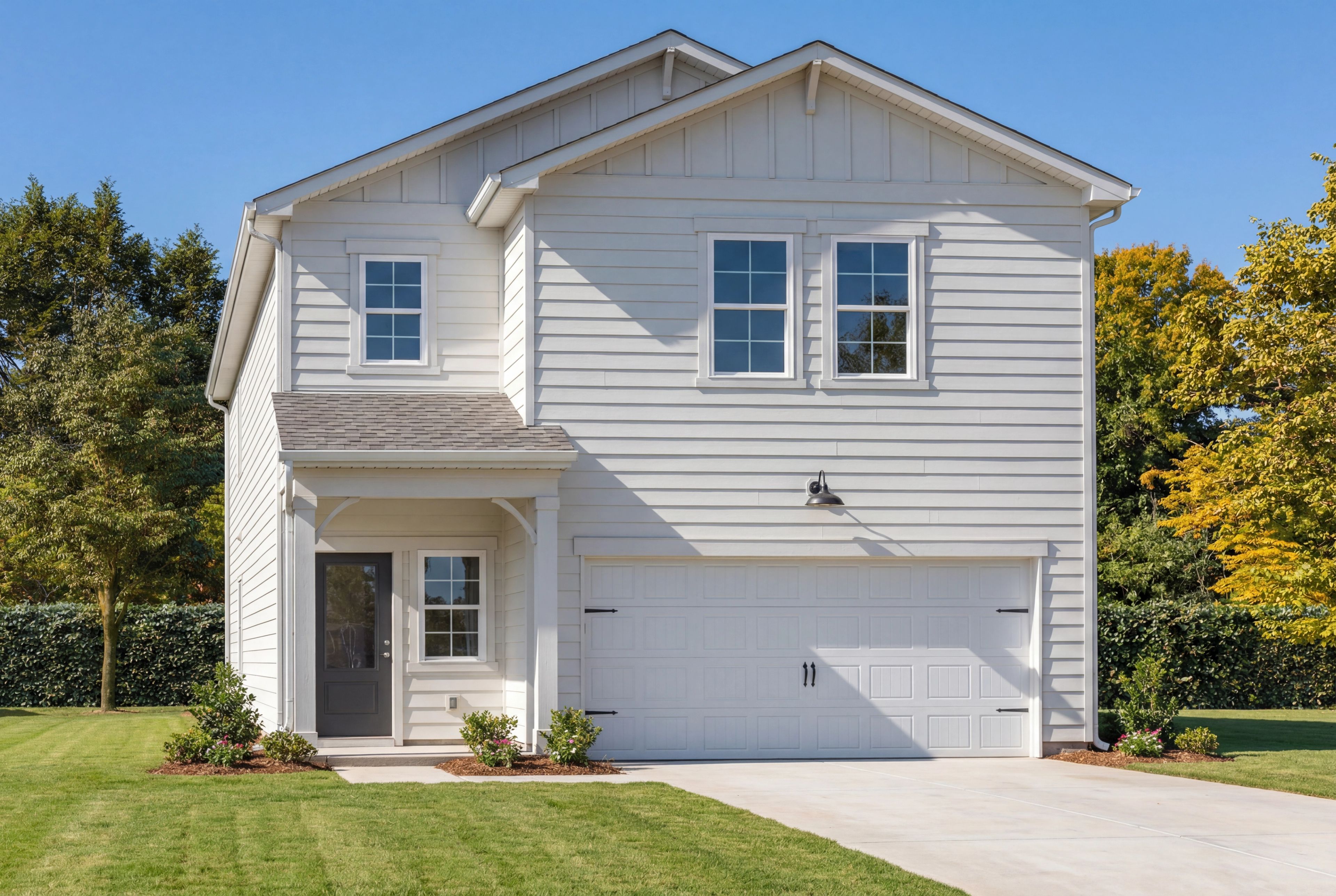 Two-story exterior elevation of The Russell B by Davidson Homes featuring white siding and a two-car garage in Cullman, AL.