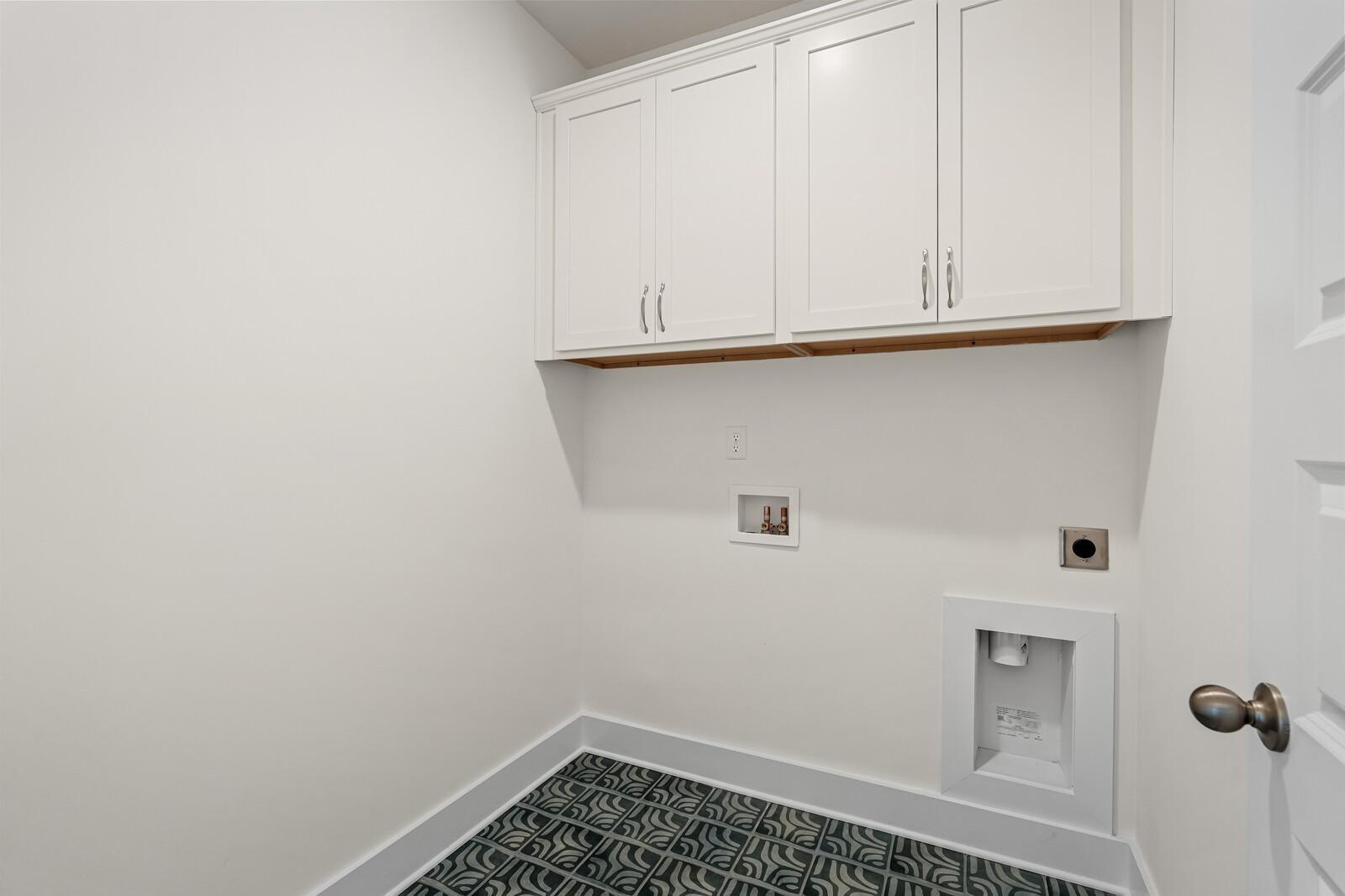 Laundry room with white cabinets and patterned tile flooring in The Ridgeport D floor plan, Benders Cove, Mt. Juliet.