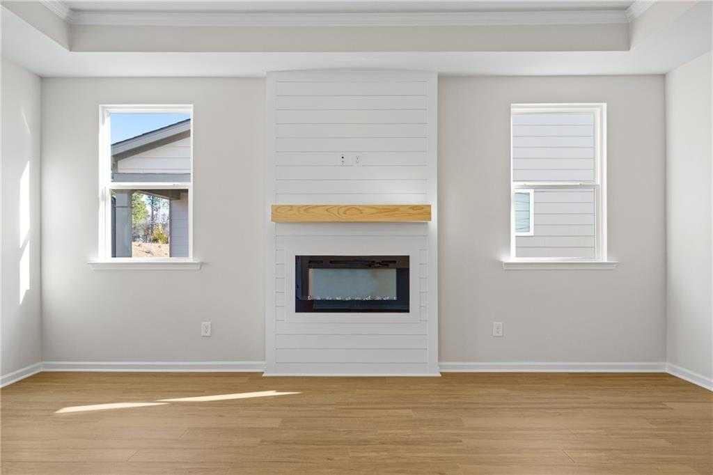 Cozy shiplap gas fireplace with oak mantel and hardwood floors in Davidson Homes The Edison A living room, Loganville, GA