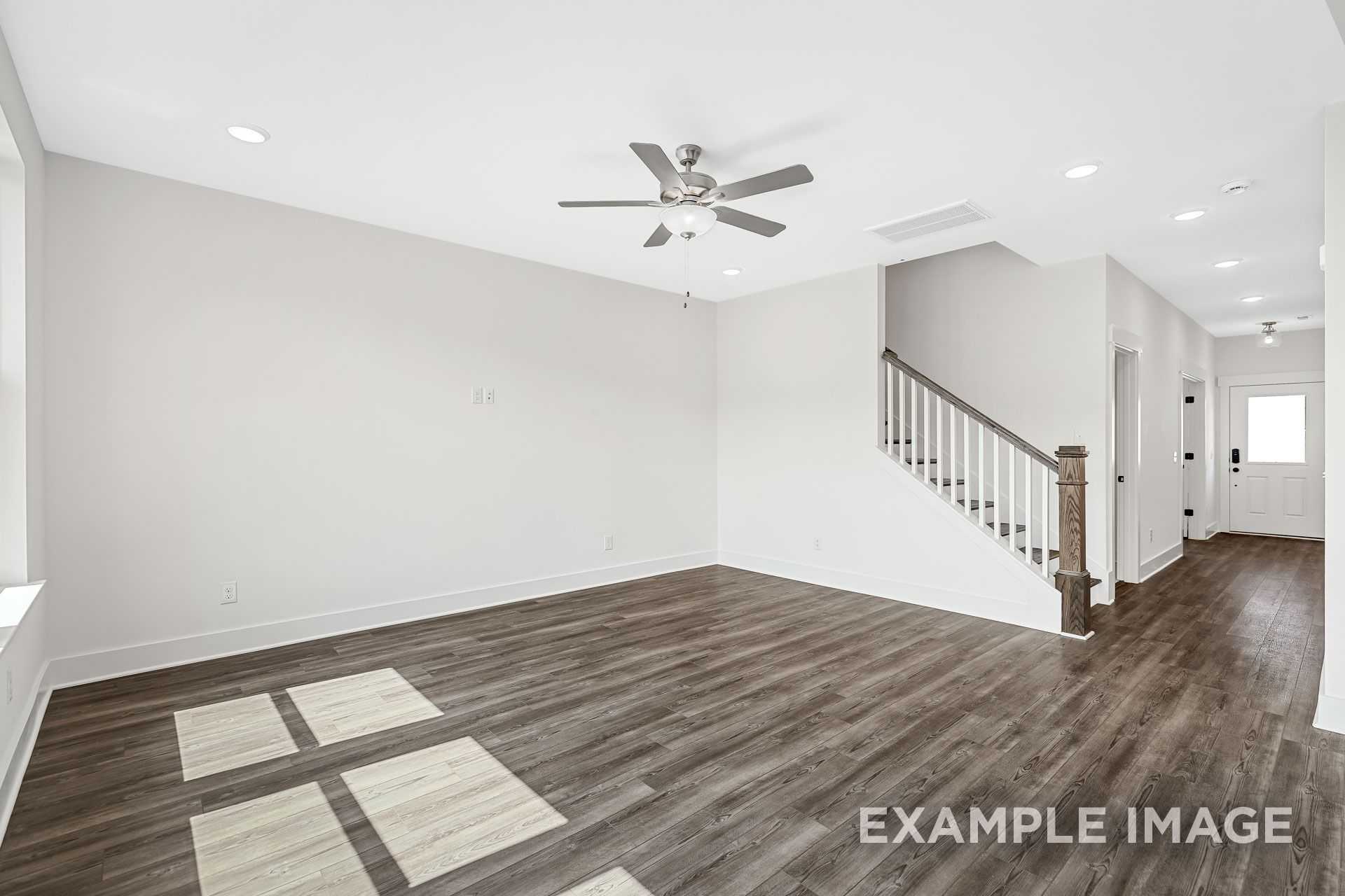 Spacious foyer in The Logan B 2-story home featuring wooden staircase, ceiling fan, hardwood floors, and neutral walls