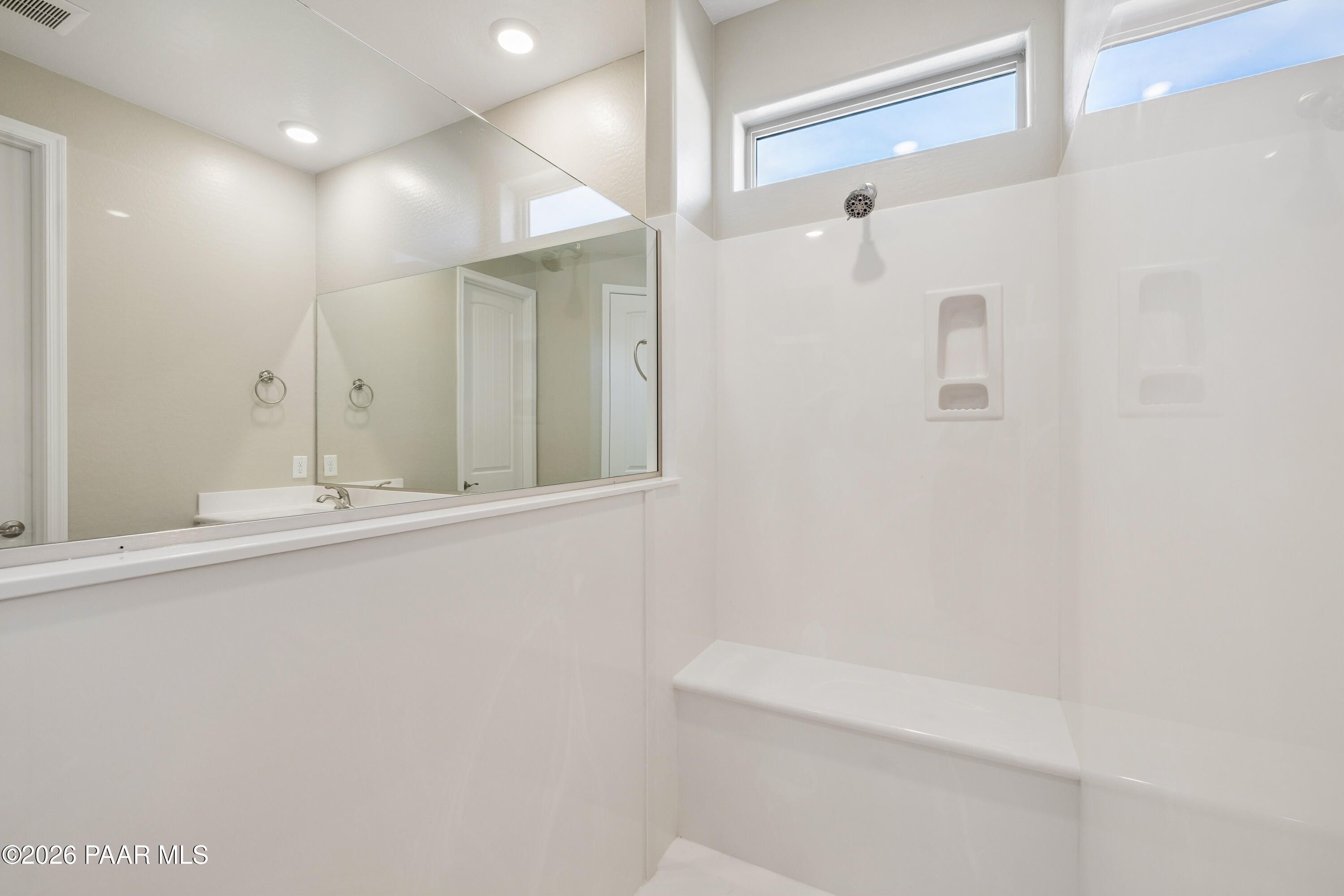 Modern master bathroom with frameless glass shower, white subway tile, and vanity in Davidson Homes The Harmony A, Prescott Valley, AZ