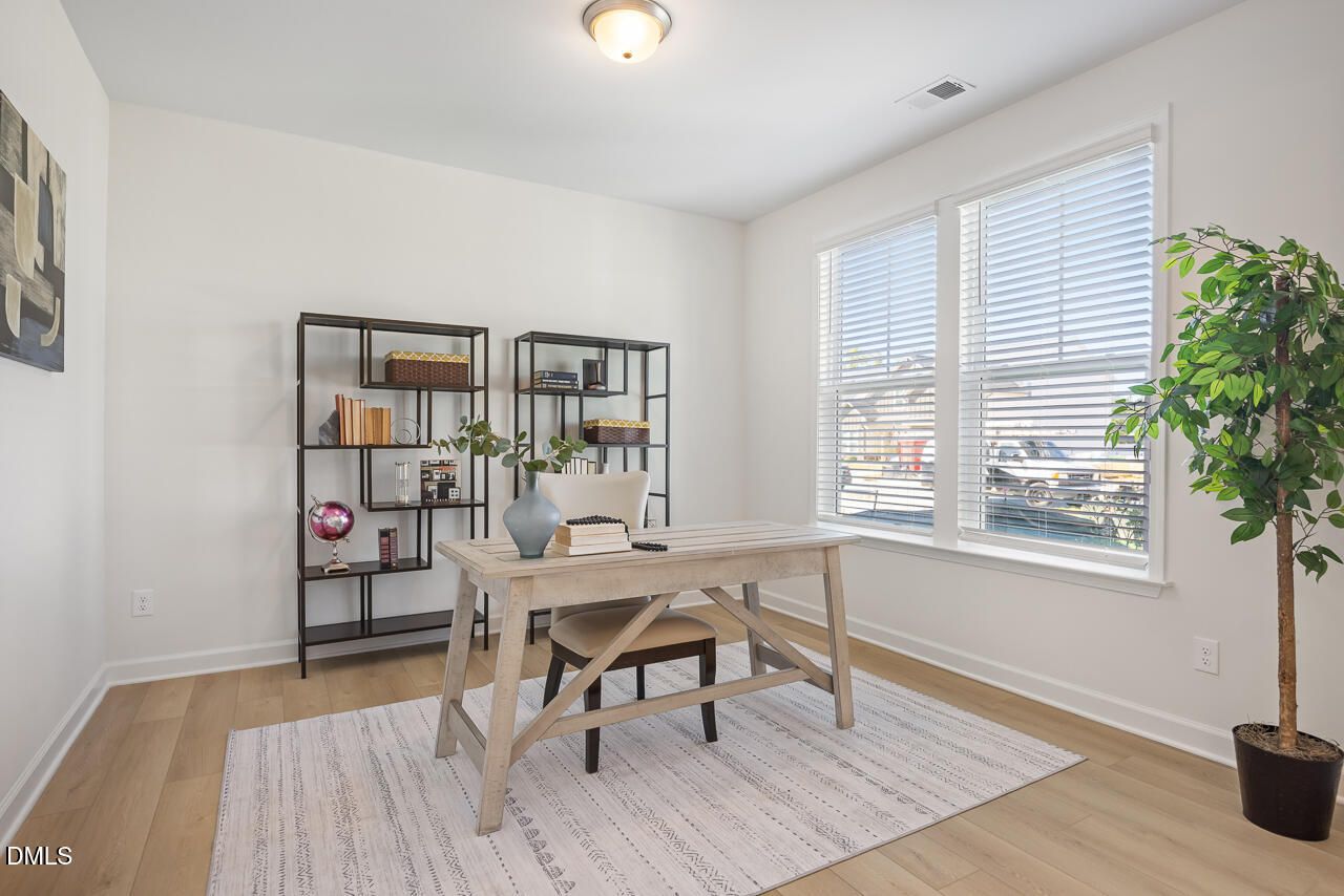 Bright home office with rustic wood desk, bookshelves, and natural light in Davidson Homes The Magnolia A, Wendell Ridge, North Carolina