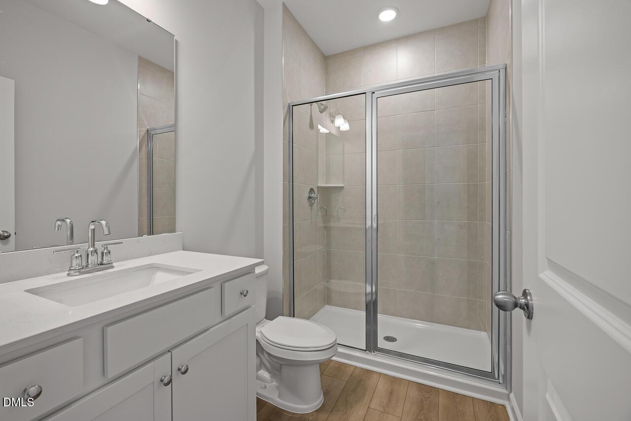 Modern bathroom with glass-enclosed shower and white vanity in The Hickory II B home by Davidson Homes in Lillington, NC.