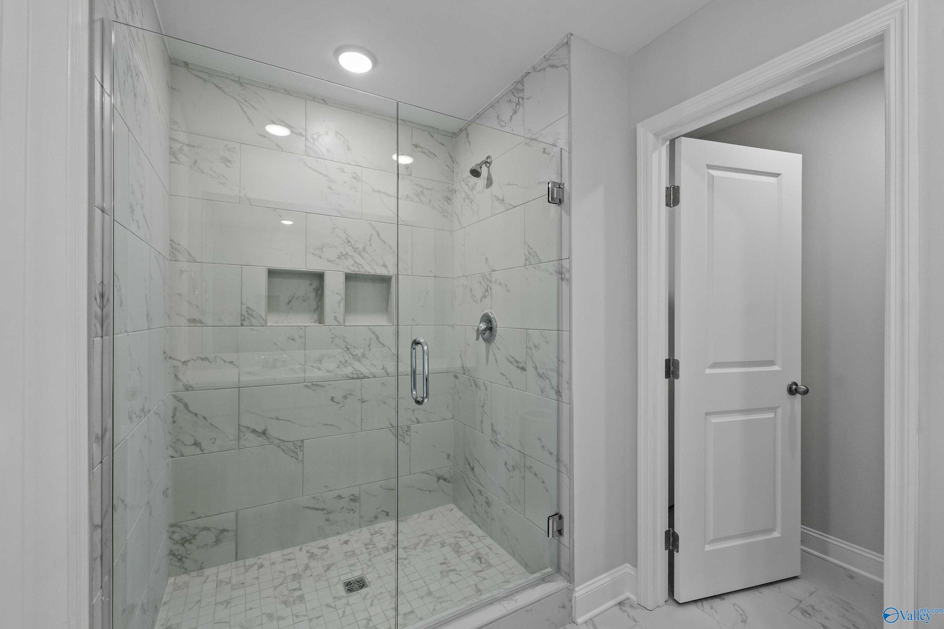 Frameless glass walk-in shower with white subway tile niches in master bath, Davidson Homes The Camden B, Huntsville AL