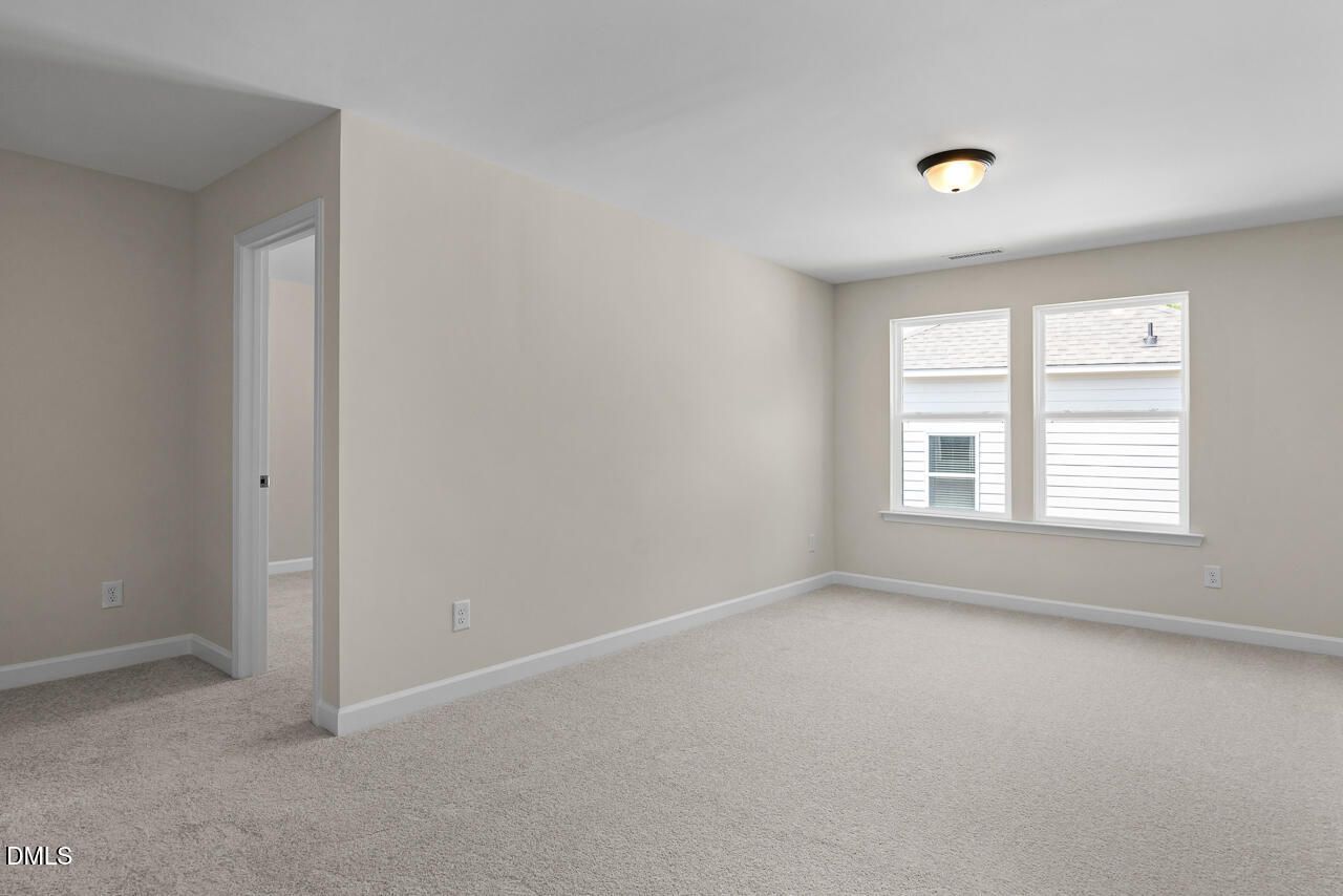 Bright carpeted bedroom with dual windows and neutral walls in Davidson Homes' The Birch II C, Wake Forest, North Carolina
