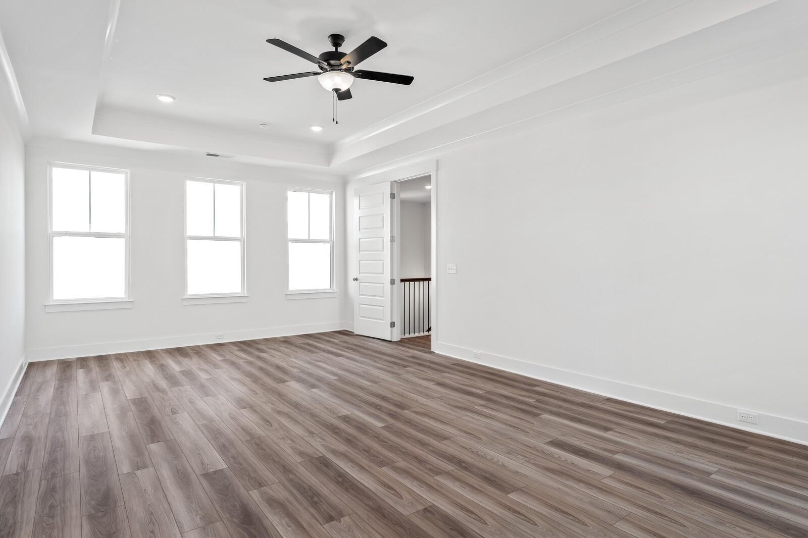 Spacious empty bonus room with hardwood floors, large windows, ceiling fan in The Alston A by Davidson Homes, Murfreesboro