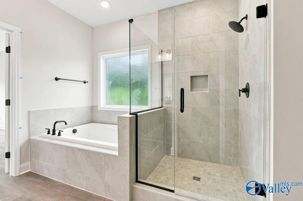 Modern master bath with garden tub and glass walk-in shower in The Rockford floor plan by Davidson Homes, Hartselle, Alabama
