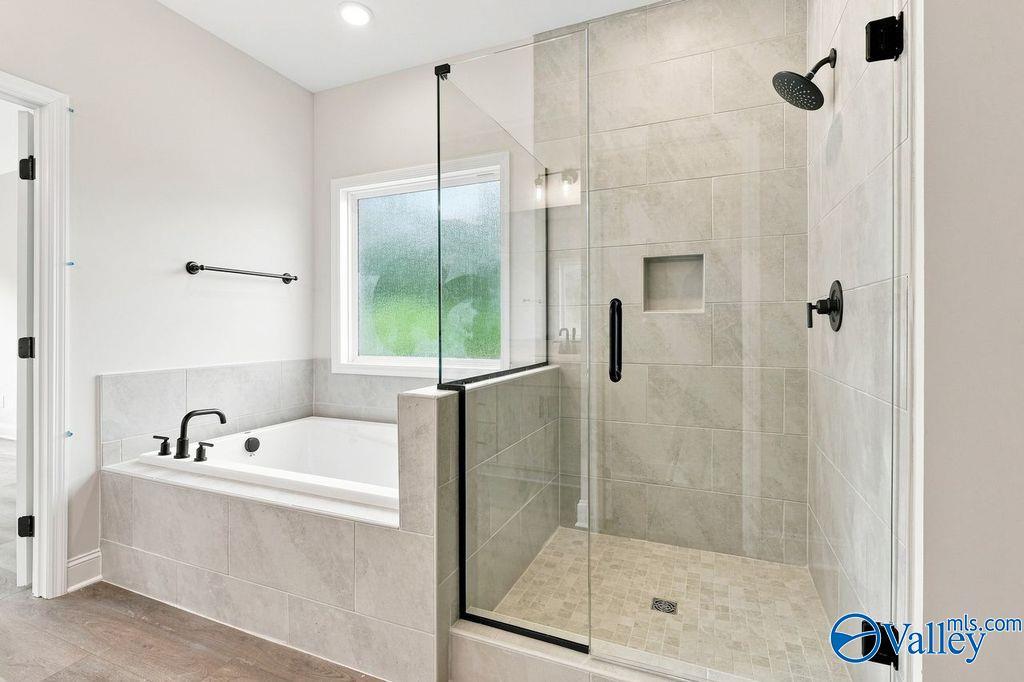 Modern master bath with garden tub and glass walk-in shower in The Rockford floor plan by Davidson Homes, Hartselle, Alabama