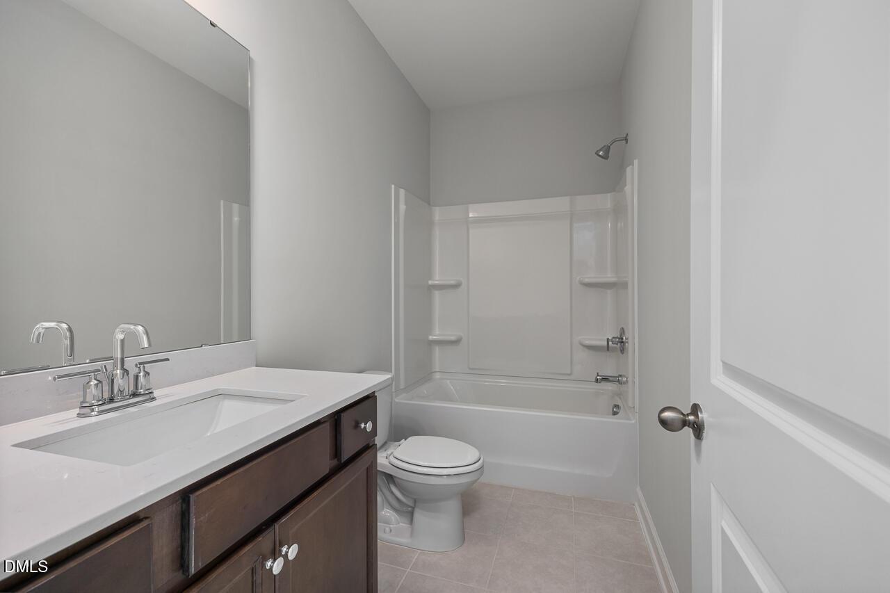 Modern bathroom with white tub-shower combo and vanity in The Daphne D floor plan at Woodland Crossing, Zebulon, NC.
