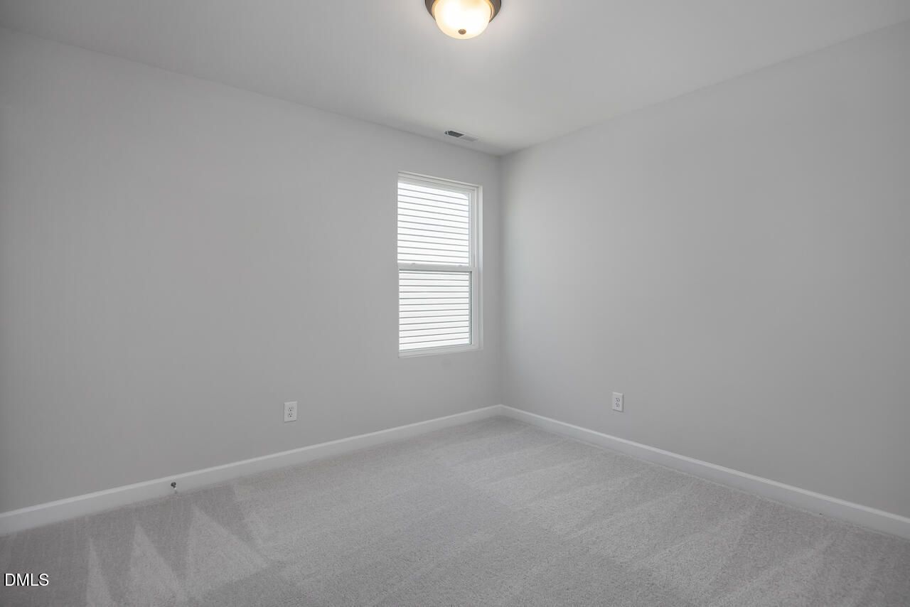 Bright, neutral-toned bedroom in The Adalynn B floor plan at Gregory Village, Lillington, NC.