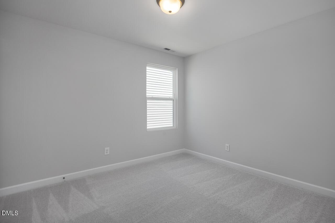 Bright, neutral-toned bedroom in The Adalynn B floor plan at Gregory Village, Lillington, NC.