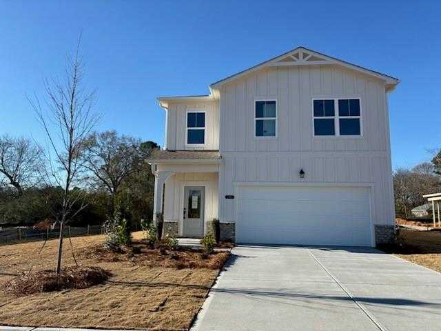 Two-story white Rabun C home by Davidson Homes in Cedar Farms, Winder, Georgia: 2-car garage, front porch, landscaped yard