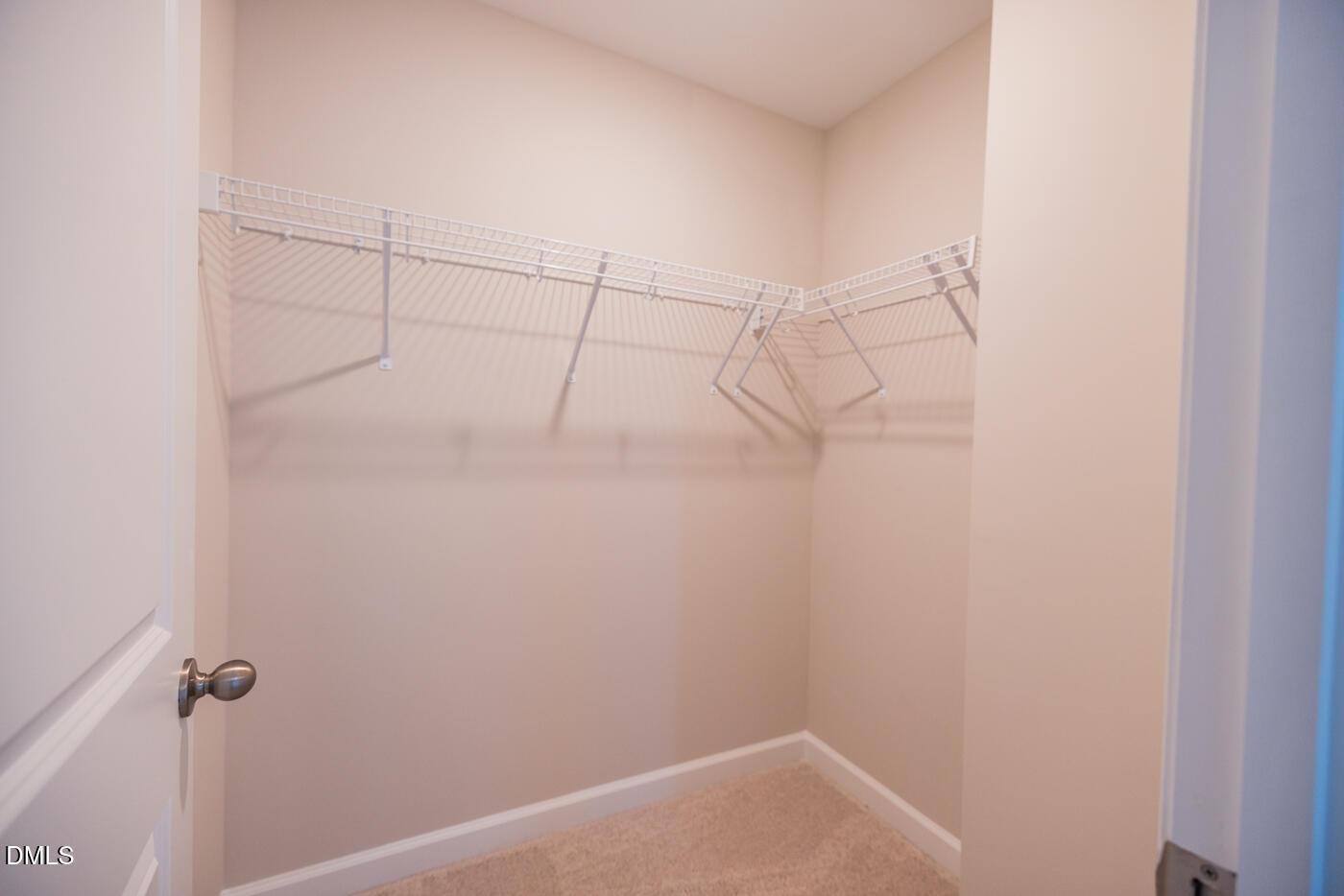 Spacious walk-in closet with wire shelving and hanging rods in master suite of The Hickory II C, Woodland Crossing, Zebulon, NC