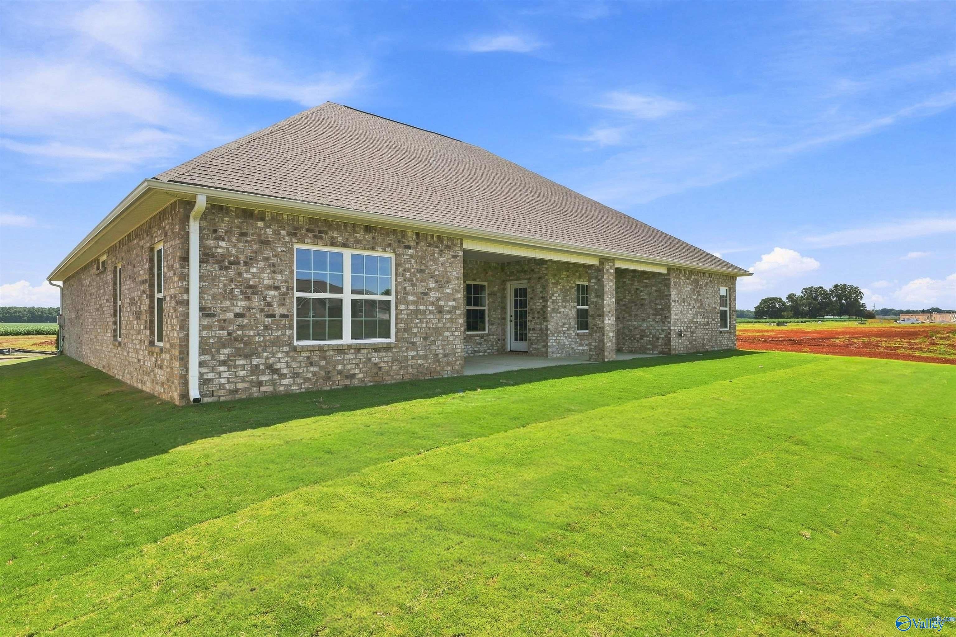 Brick exterior of The Oxford floor plan by Davidson Homes with covered patio in Kendall Farms, Toney, Alabama.