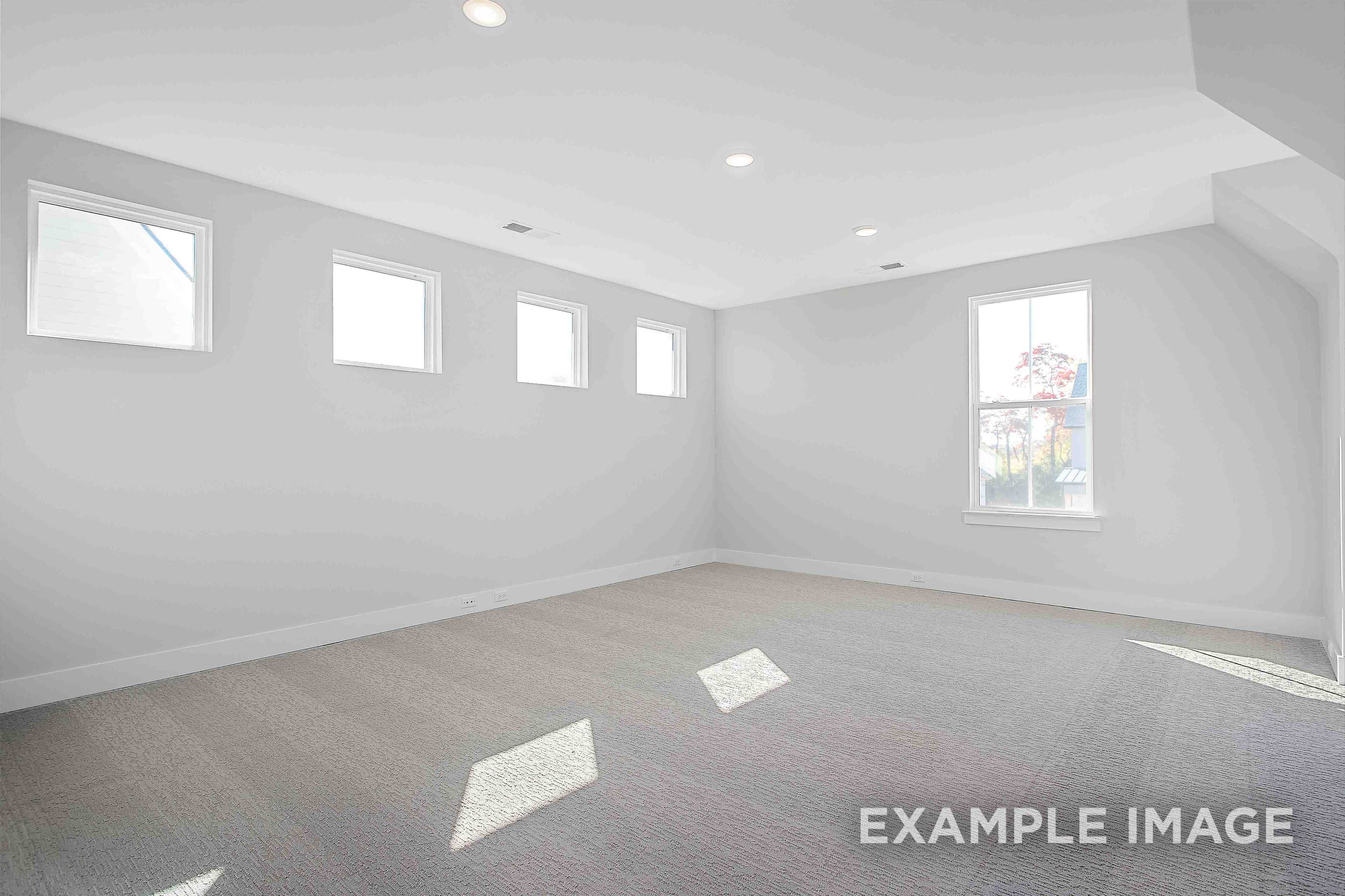 Spacious upper-floor master bedroom in The Alston A with light gray walls, multiple windows, hardwood floors, and recessed lighting