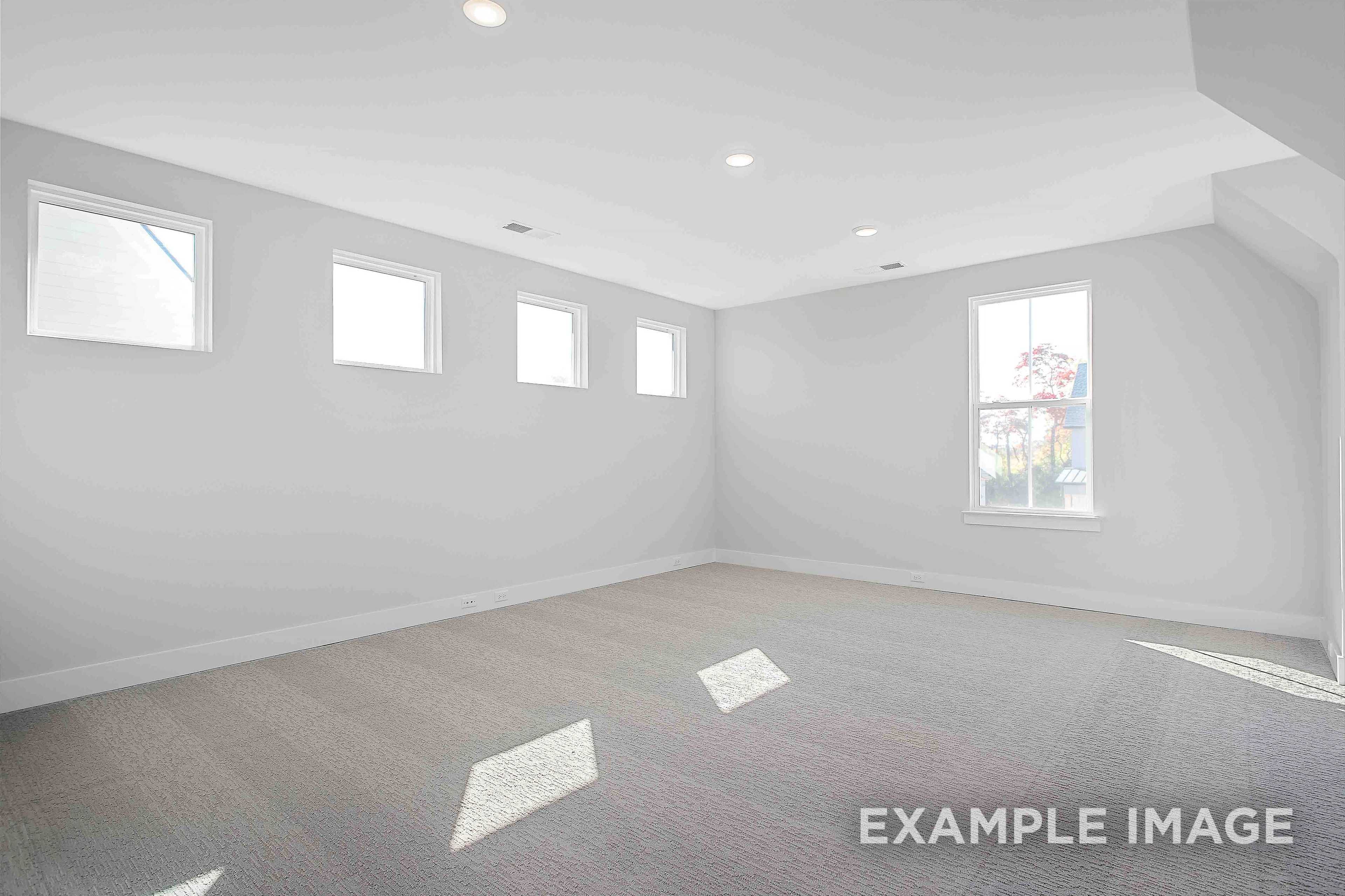 Spacious upper-floor master bedroom in The Alston A with light gray walls, multiple windows, hardwood floors, and recessed lighting