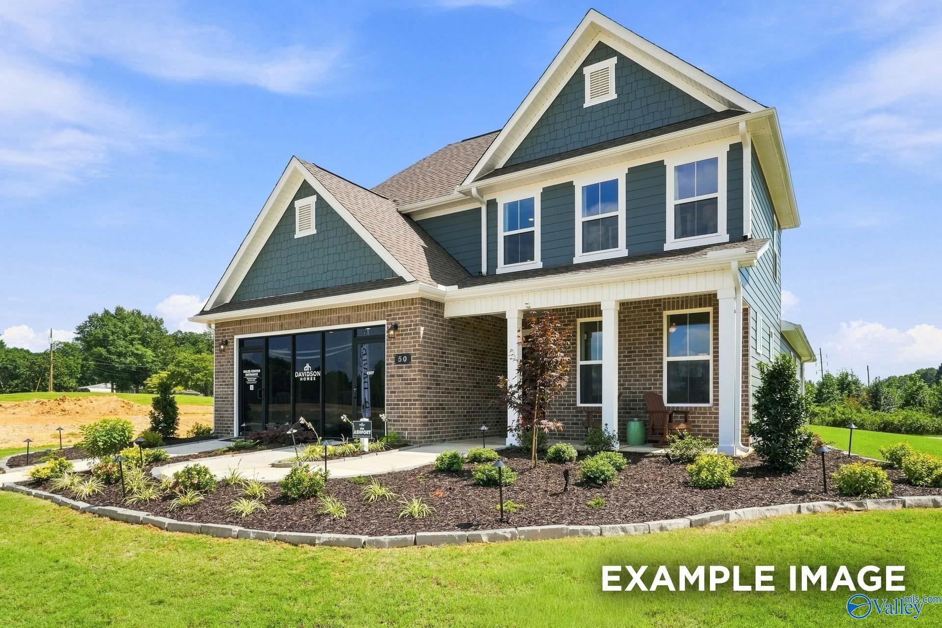 Two-story brick and siding home with covered front porch and landscaped yard in The Ashport L plan, Berry Cove, New Market, Alabama