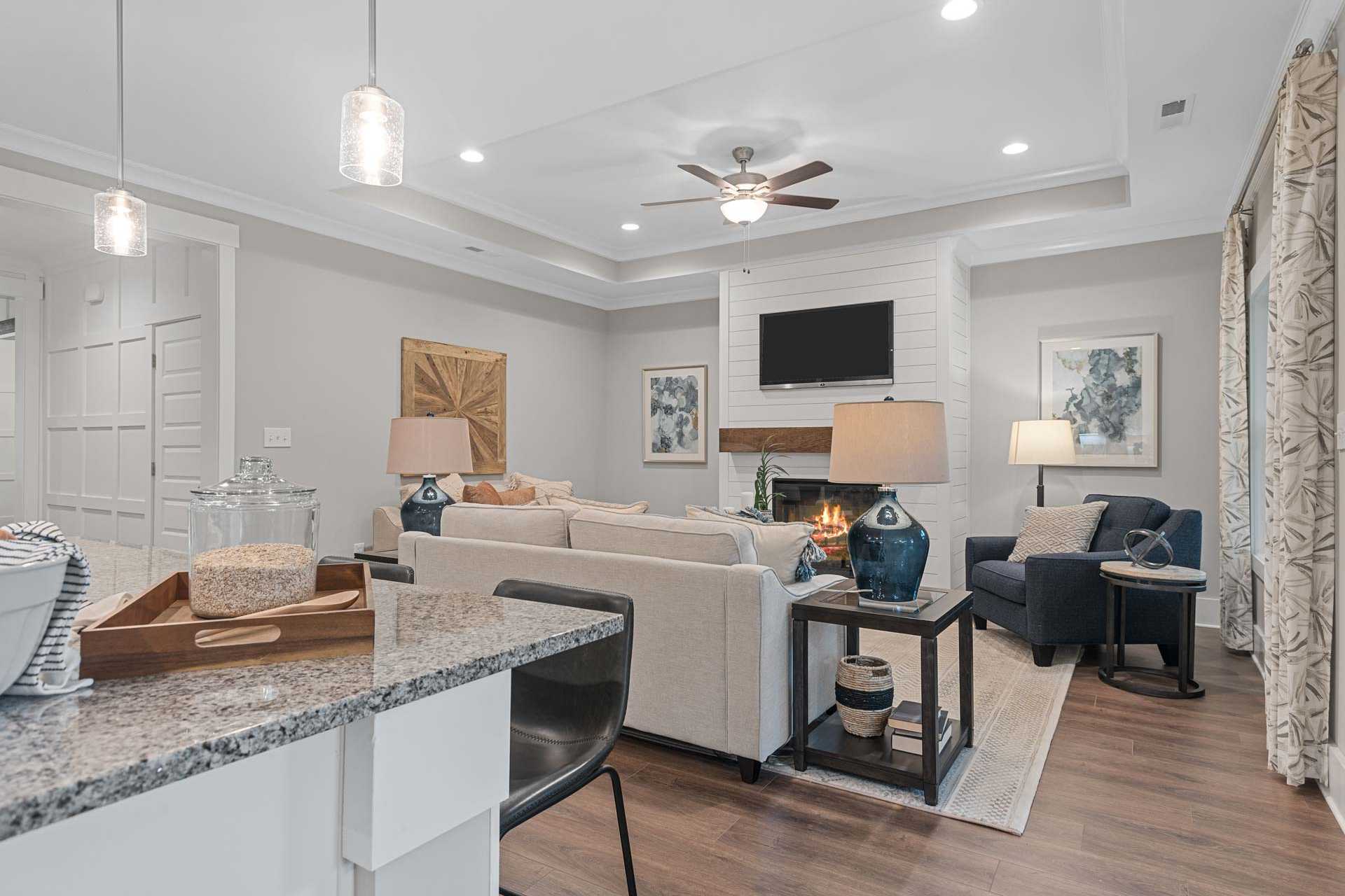 Open-concept living room at Monteagle Cove in Owens Cross Roads, Alabama featuring shiplap fireplace, beige sofa, and hardwood floors