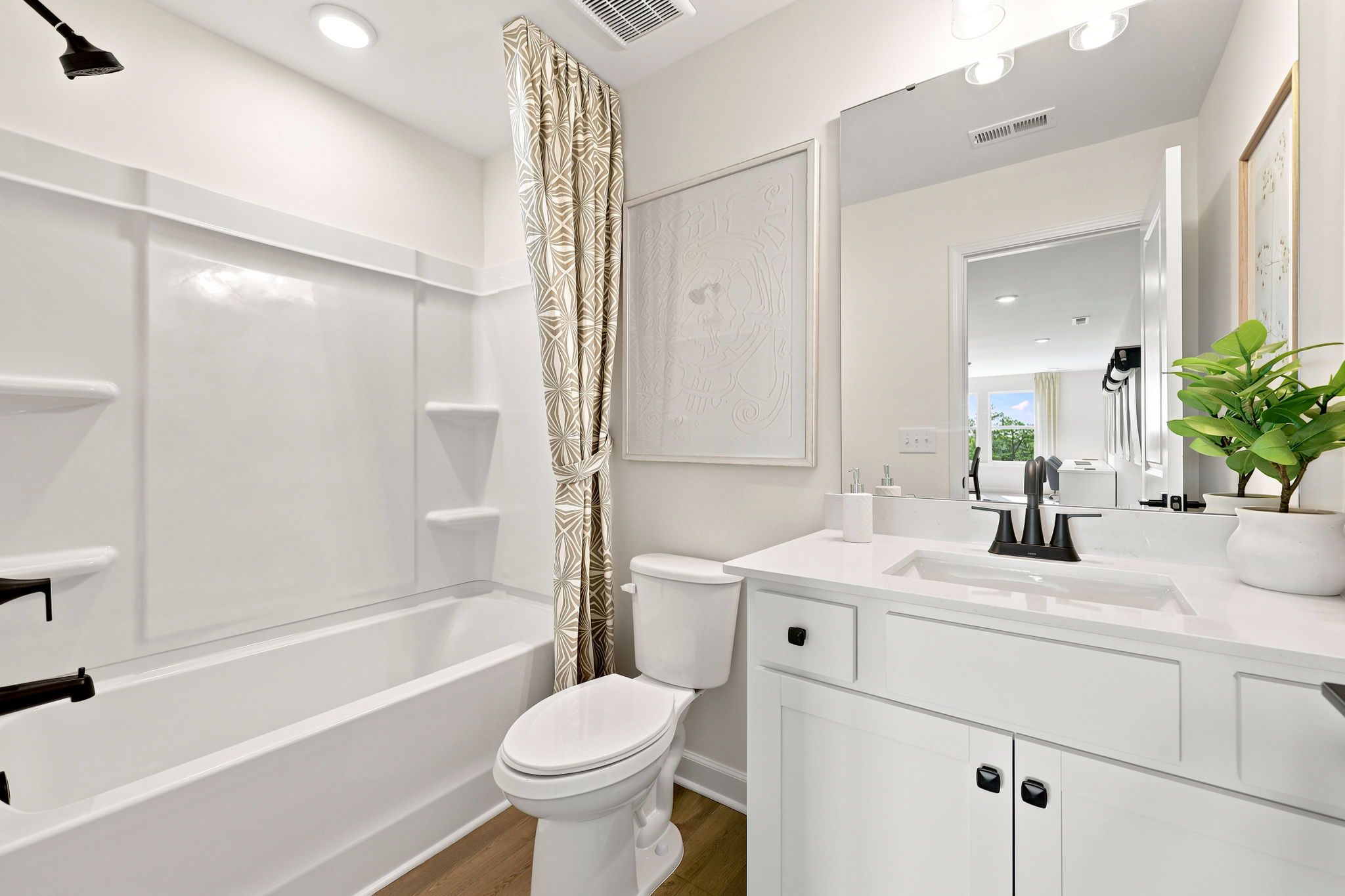 Modern bathroom at Montrose in Aberdeen, NC by Davidson Homes with white vanity, matte black fixtures, and tub-shower combo.