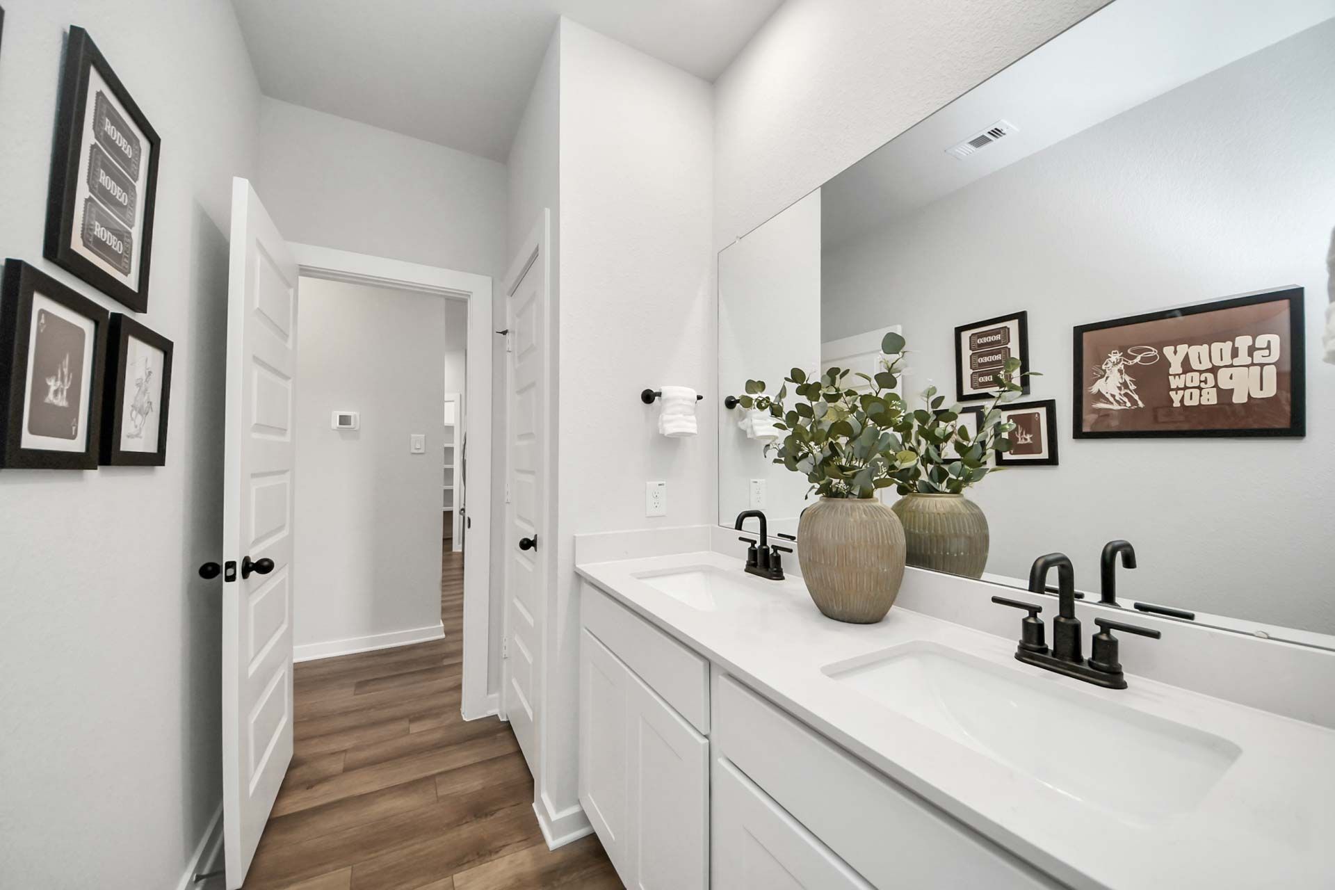 Modern double vanity bathroom at Enclave at Newport in Crosby, Texas by Davidson Homes with matte black fixtures.
