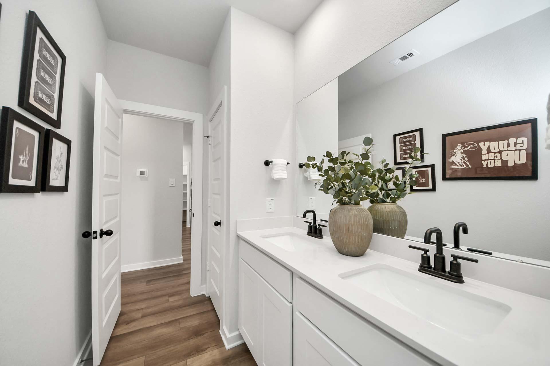 Modern double vanity bathroom at Enclave at Newport in Crosby, Texas by Davidson Homes with matte black fixtures.