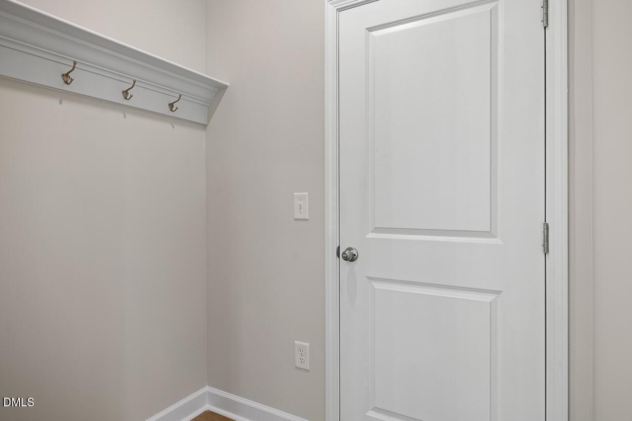 Mudroom drop zone with white wall hooks in The Chestnut floor plan at Montrose in Aberdeen, North Carolina.