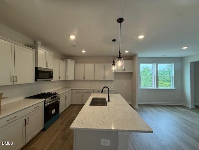 Modern kitchen with white cabinets, island, and pendant lighting in The Birch II A floor plan, Montrose, Aberdeen, NC.