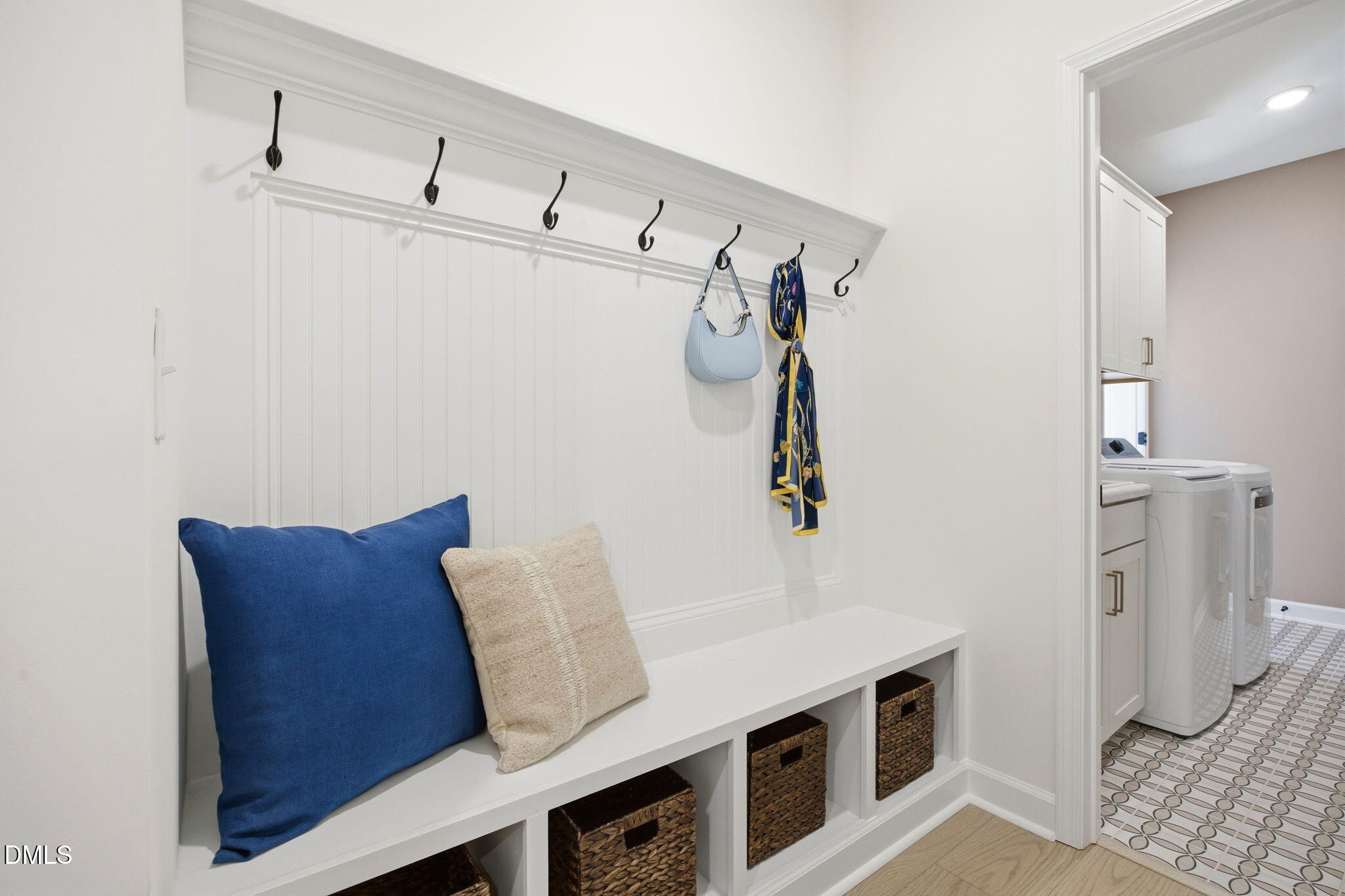 Mudroom bench with coat hooks and storage baskets in The Ashport M floor plan at Wendell Ridge, Wendell, North Carolina.