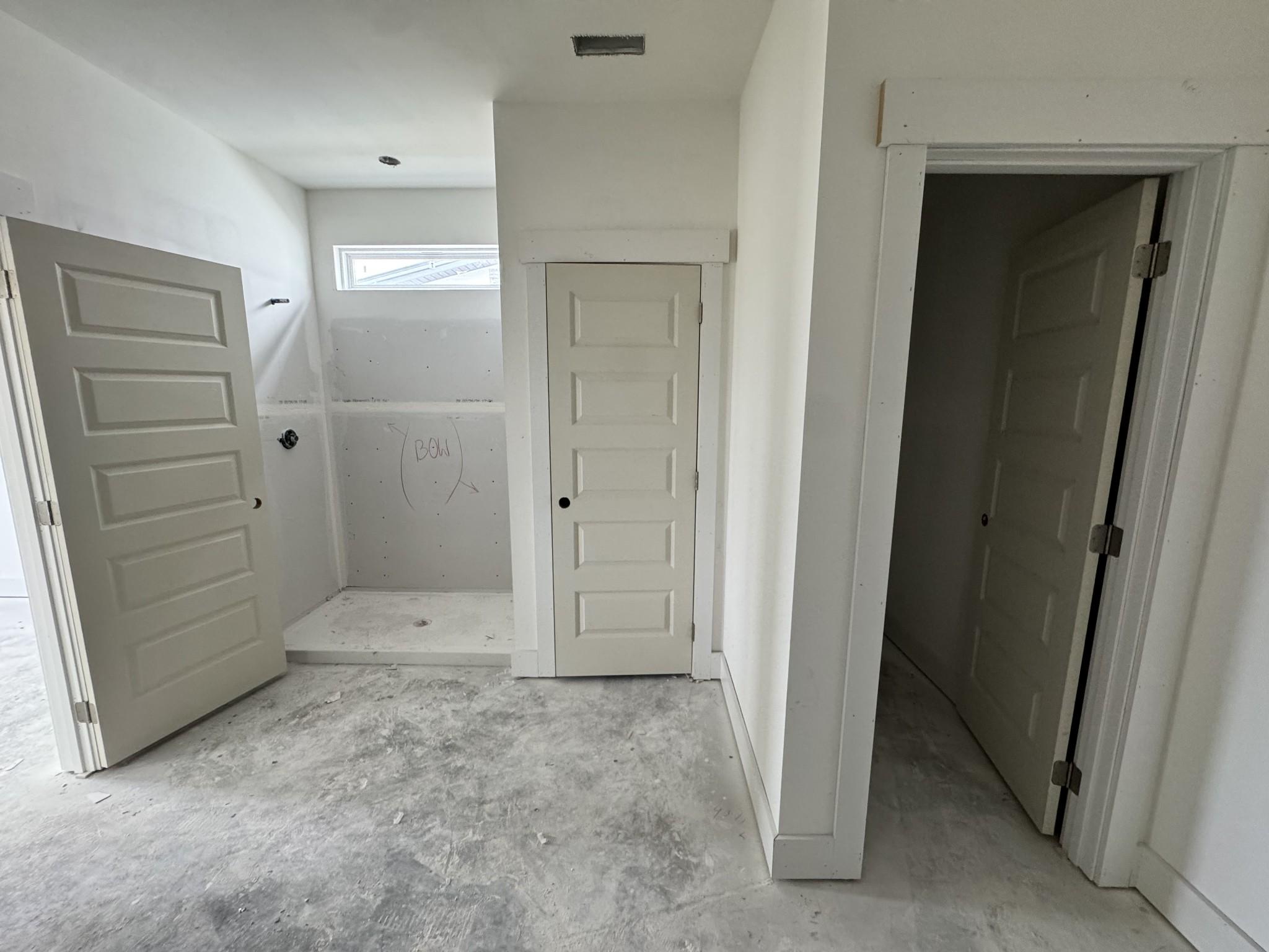 Spacious master bathroom with frameless glass shower enclosure and walk-in closet access in Davidson Homes The Cottonwood E, Gallatin, TN