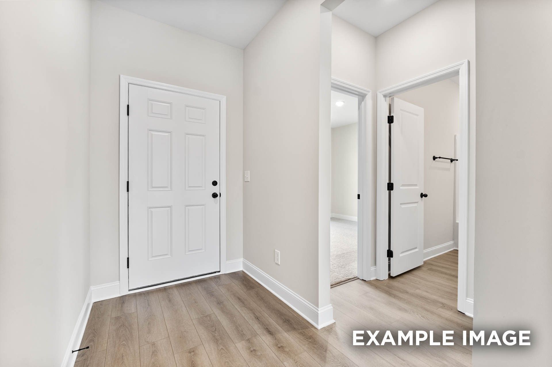Entryway with luxury plank flooring and doorway access to bedrooms in The Franklin E floor plan at Bailey Park.