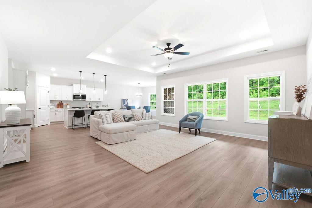 Open-concept living room with tray ceiling and kitchen in The Rockford B floor plan at Cain Park, Hartselle, Alabama.