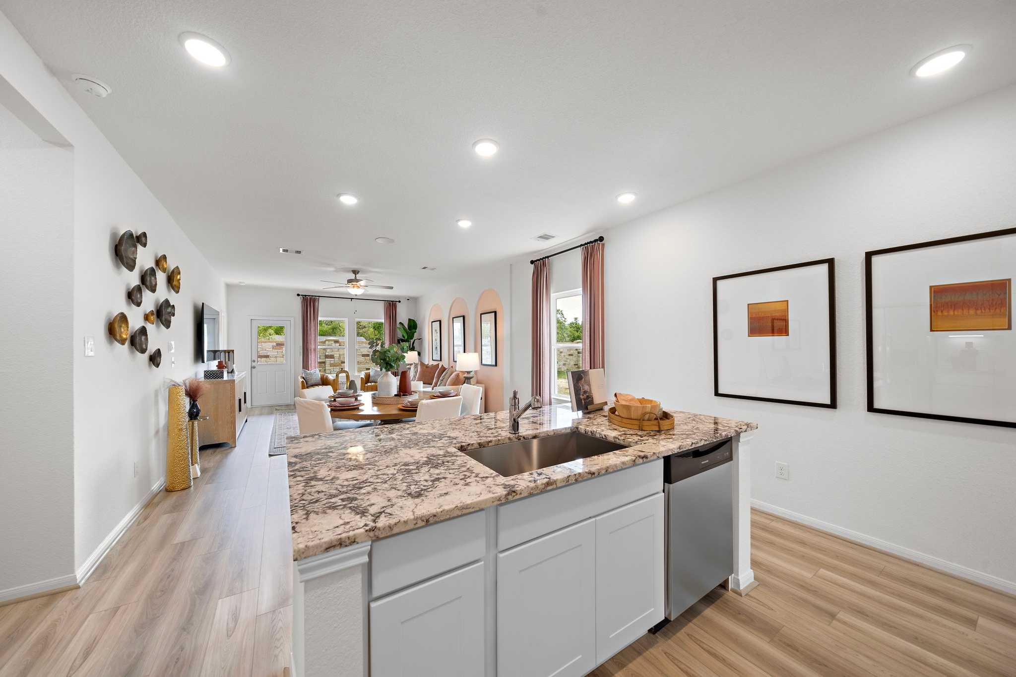 Spacious open-concept kitchen and living room at The Villages at WestPointe in Dayton TX with quartz island white cabinets hardwood floors