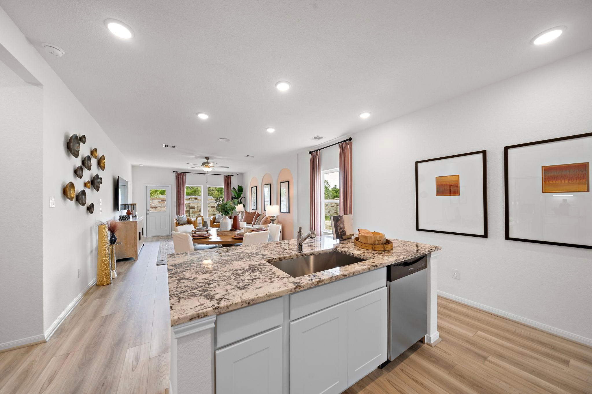 Spacious open-concept kitchen and living room at The Villages at WestPointe in Dayton TX with quartz island white cabinets hardwood floors