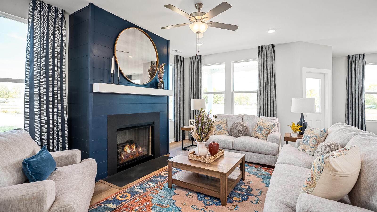 Cozy living room at Sage Farms in White House TN with navy blue fireplace, round mirror, plush sofas and patterned rug
