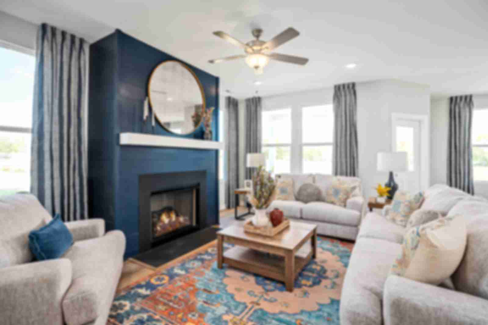 Cozy living room at Sage Farms in White House TN with navy blue fireplace, round mirror, plush sofas and patterned rug