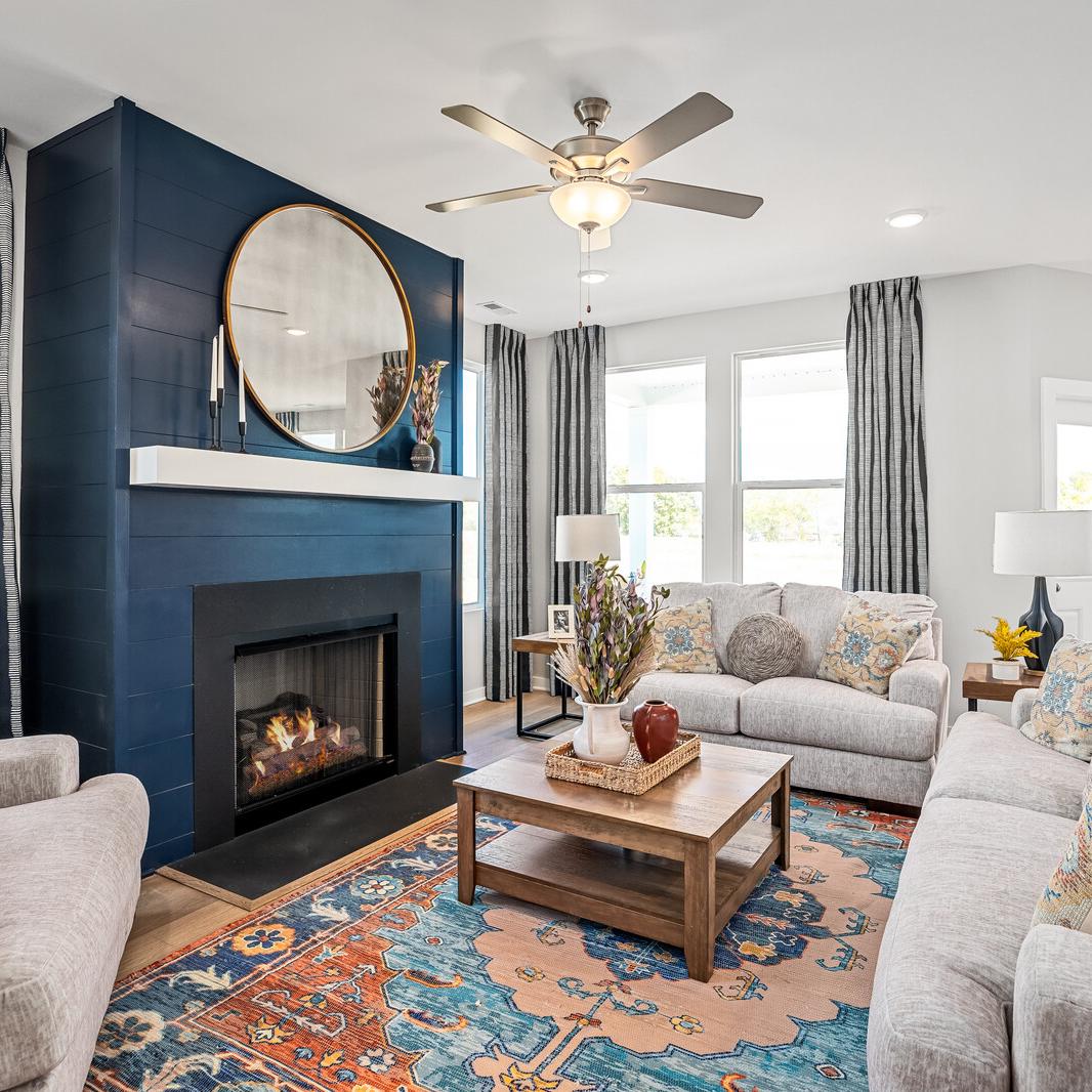 Cozy living room at Sage Farms in White House TN with navy blue fireplace, round mirror, plush sofas and patterned rug