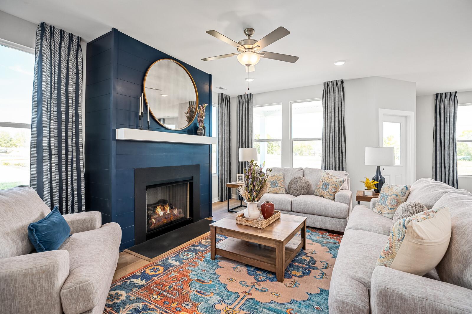 Cozy living room at Sage Farms in White House TN with navy blue fireplace, round mirror, plush sofas and patterned rug