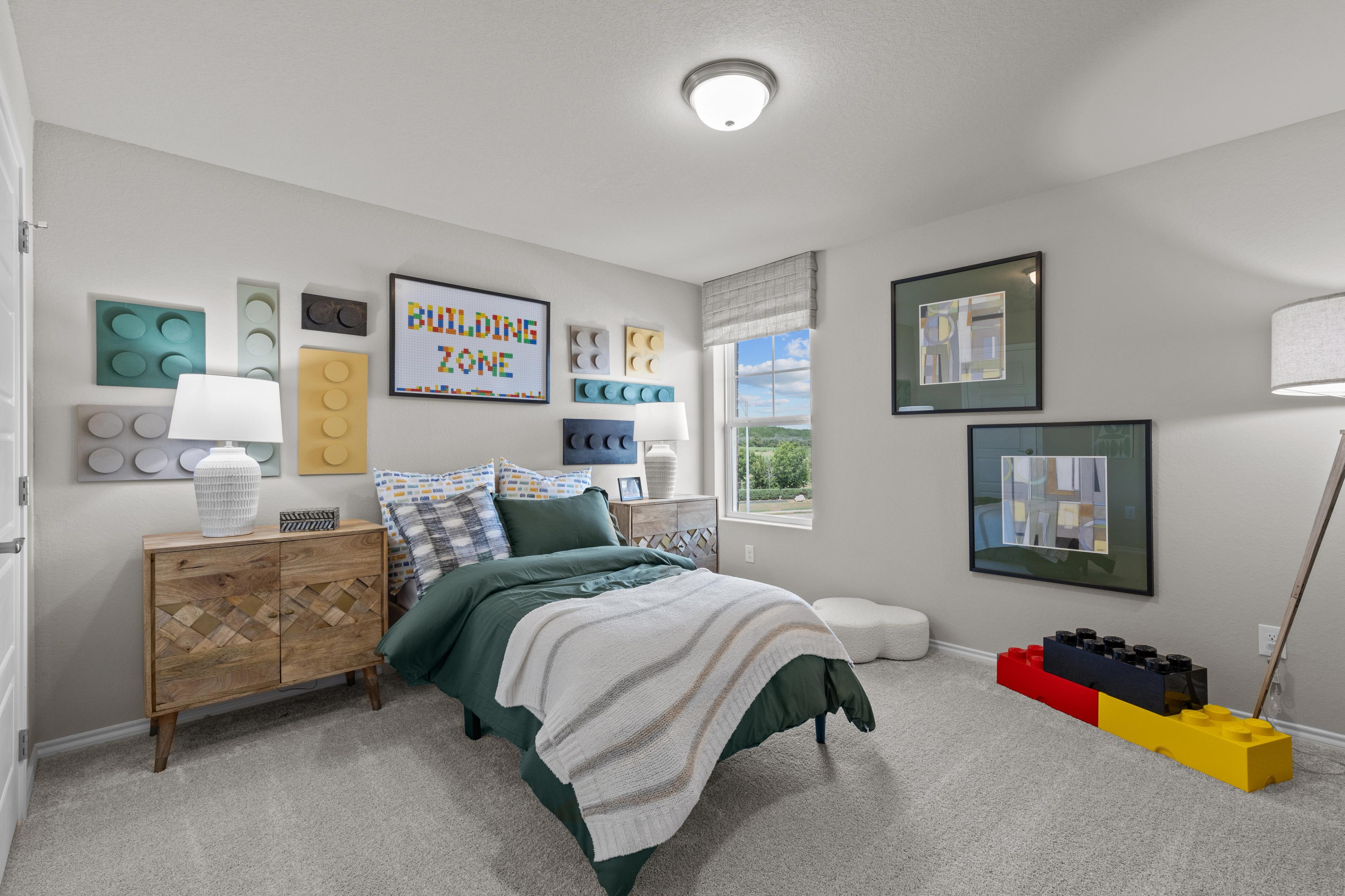 LEGO-themed children's bedroom in Comanche Ridge San Antonio TX with green twin bed dresser and building zone wall decor